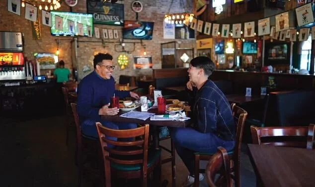 Tasha Arevalo, right, laughs with Joseph Butler while eating at Mo’s Irish Pub, March 2, in Houston. Photo The Associated Press