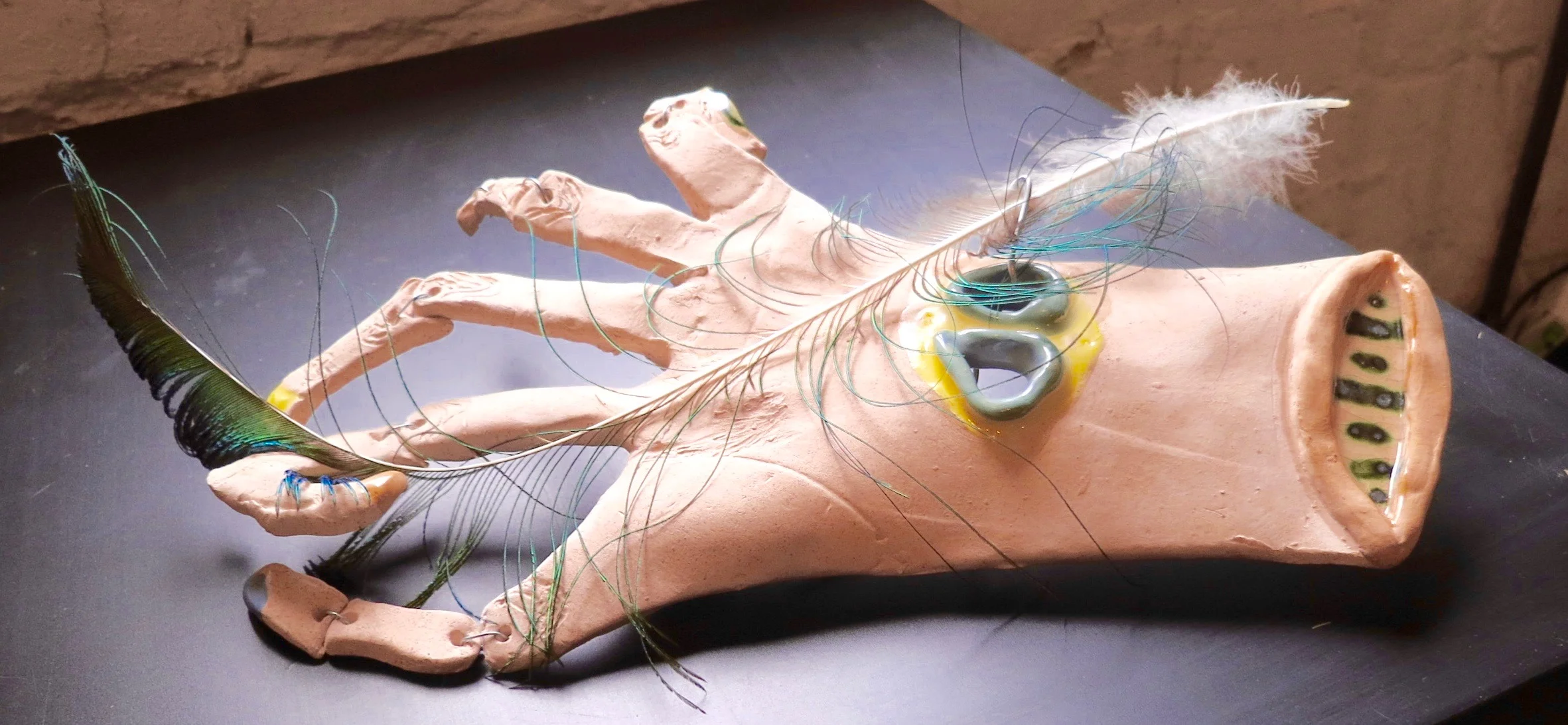 Hand with peacock feather, mixed media ceramic