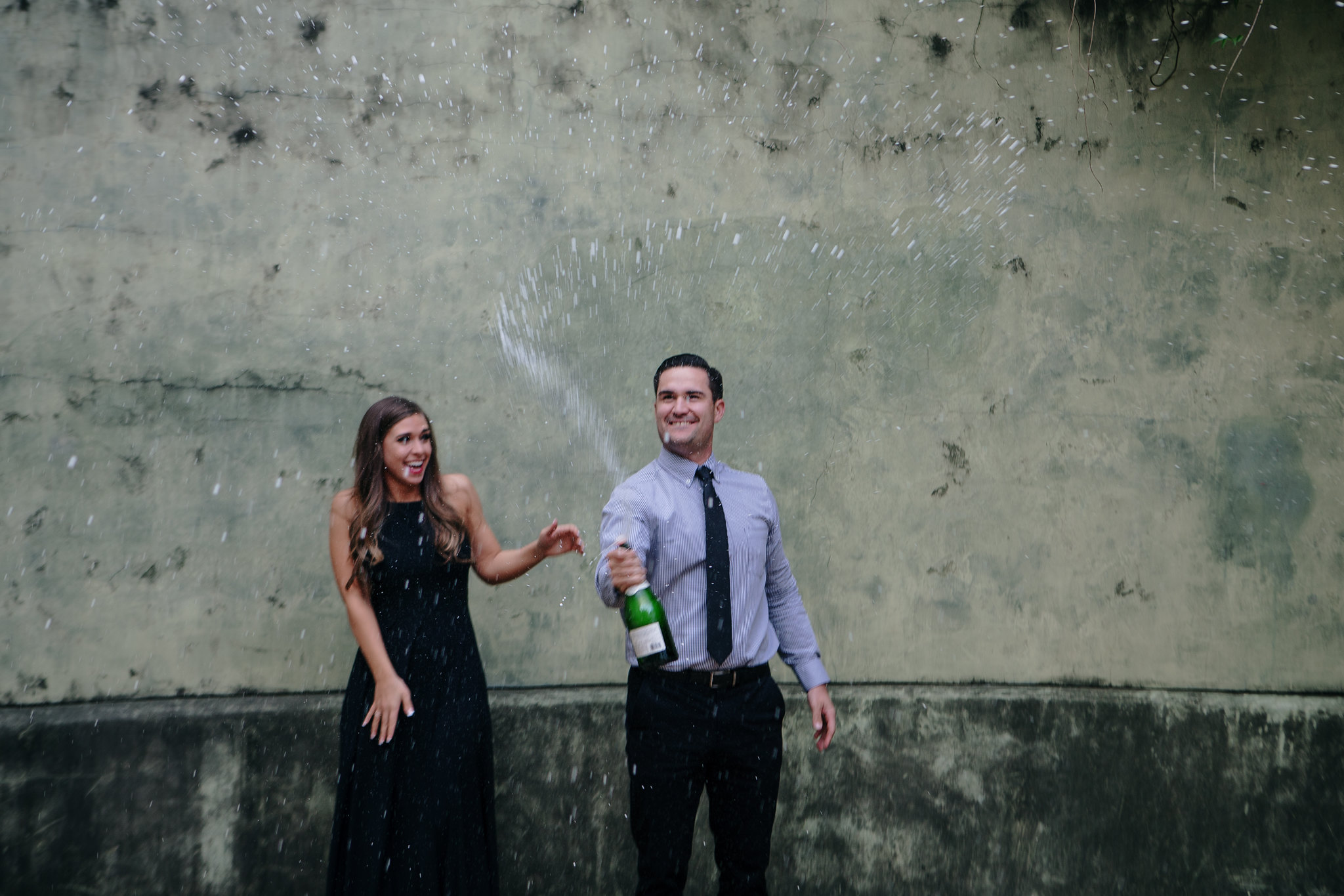 Couple popping the champagne Engagement Photo Session at Hermann Park Houston, TX