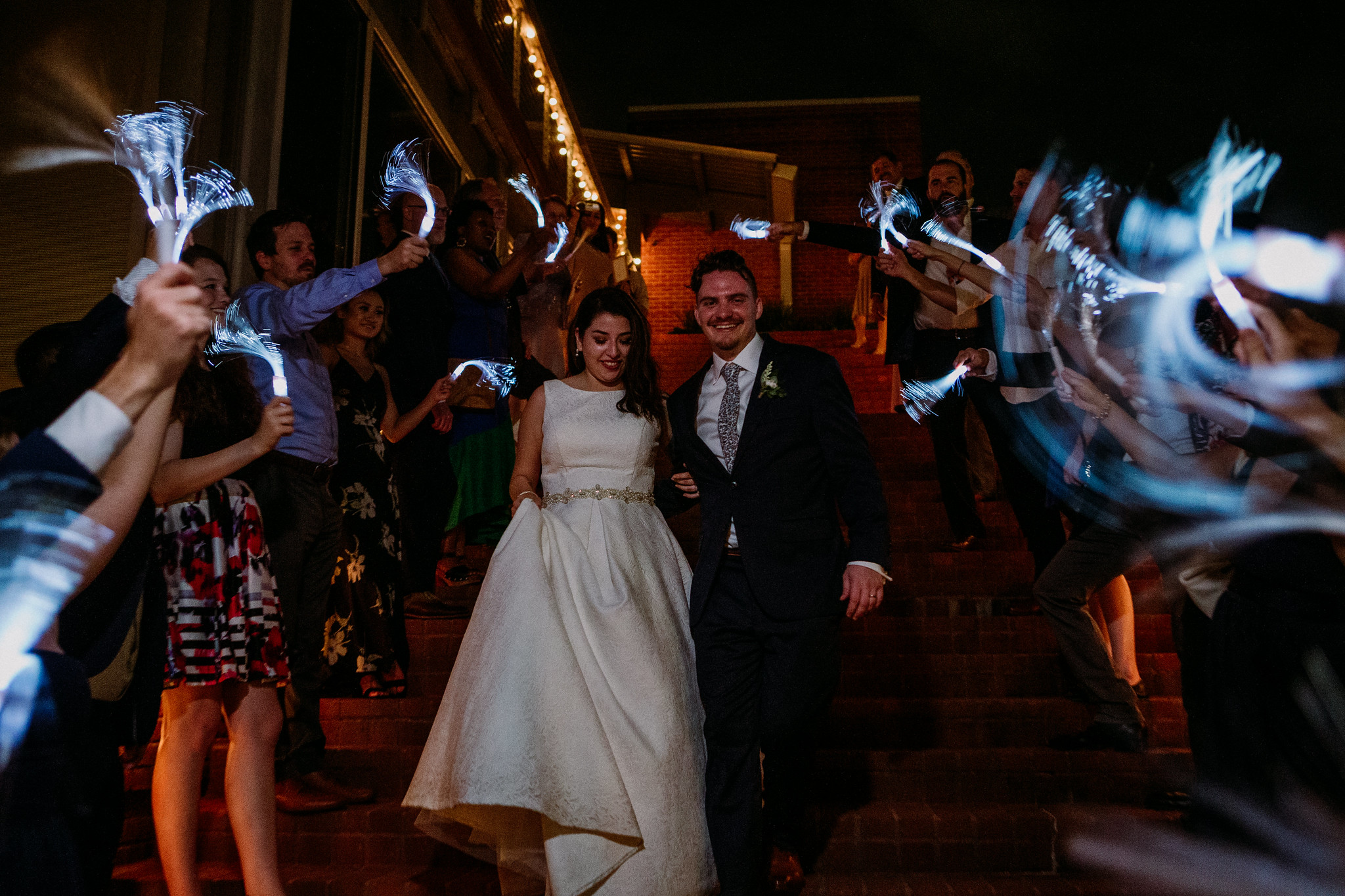 Bride and groom send off grand exit glow sticks. Reception. Wedding at The Grove at Discovery Green Park (Houston, TX)