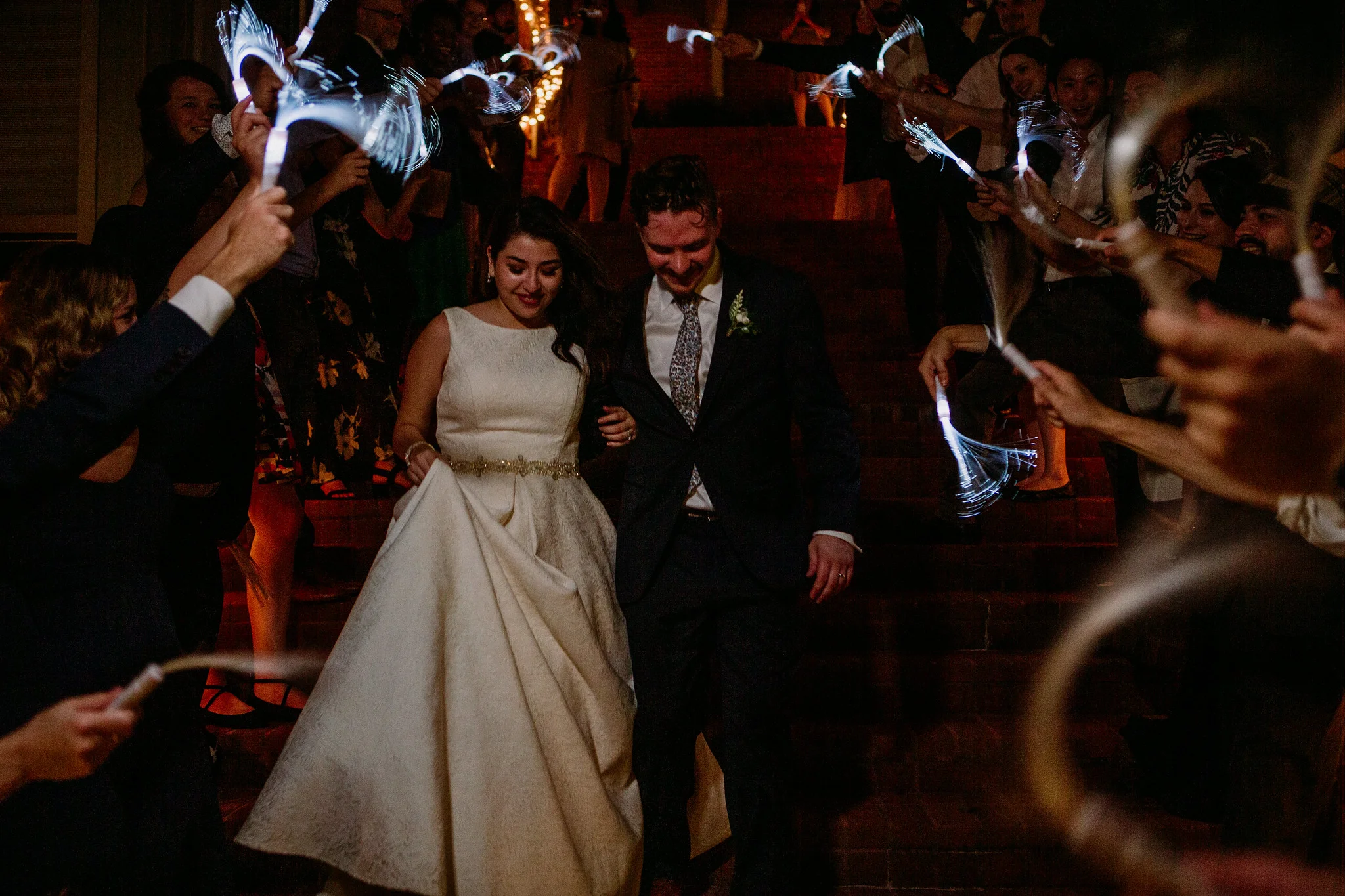 Bride and groom send off grand exit glow sticks. Reception. Wedding at The Grove at Discovery Green Park (Houston, TX)