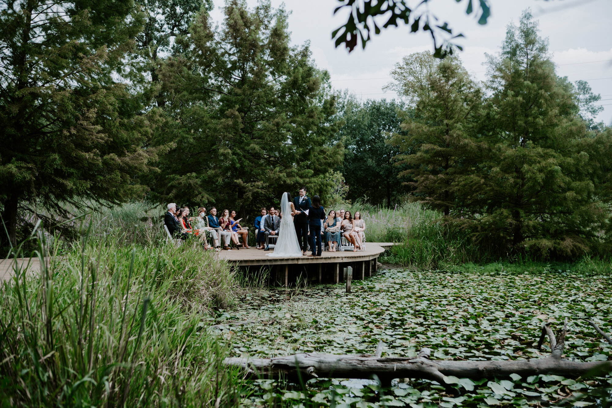 Wedding ceremony by the pond wide shot at Houston Arboretum and Nature Center