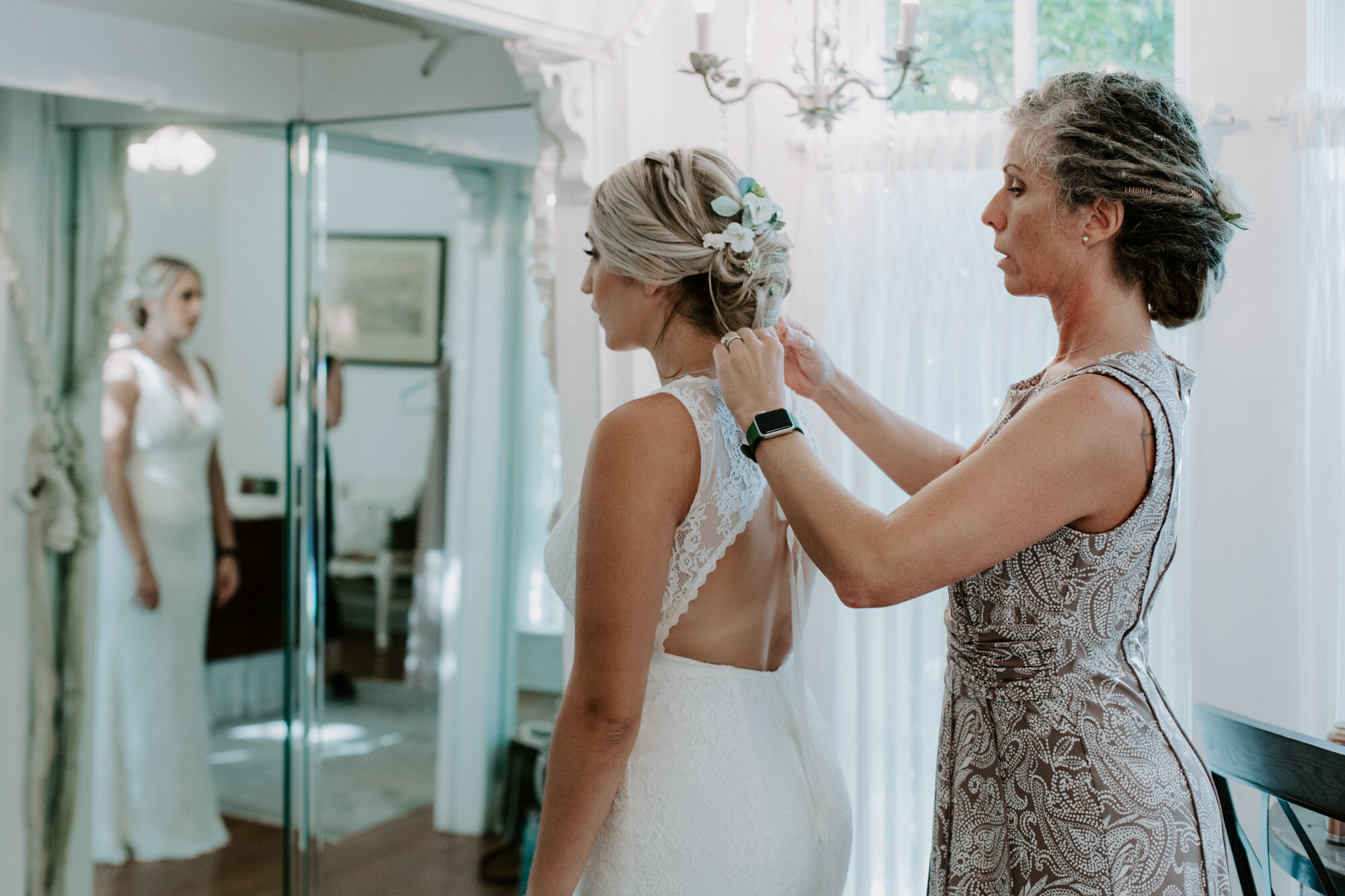Bride getting ready mother zipping the dress. Radiant Bohemian Hill Country Wedding at Gruene Estate in New Braunfels, TX