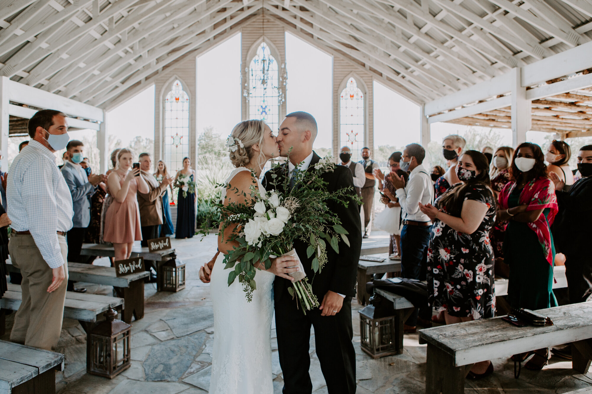 Bride and groom walking down the aisle kissing. Radiant Bohemian Hill Country Wedding at Gruene Estate in New Braunfels, TX