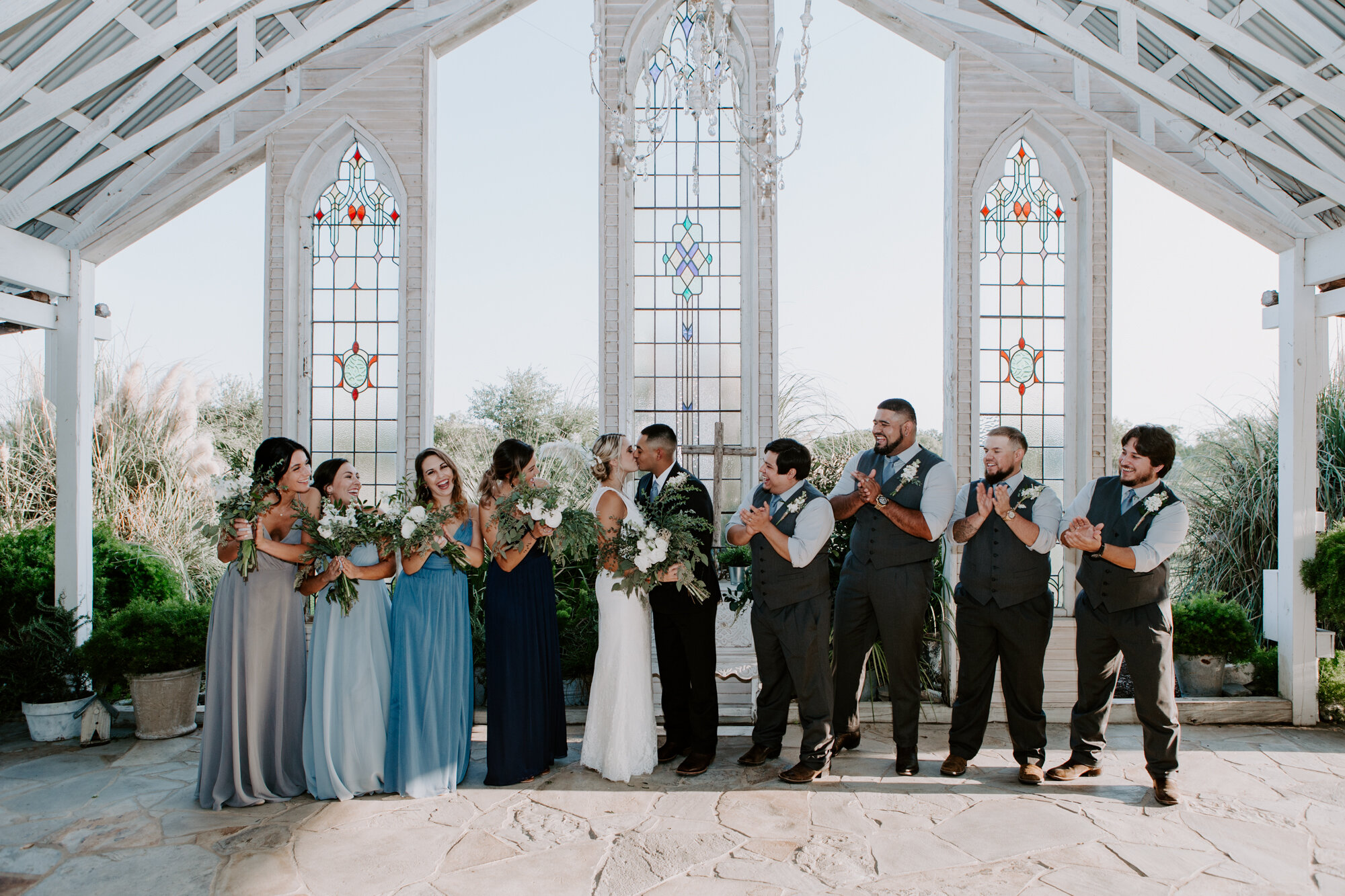 Bride and groom with bridal party inside the chapel. Radiant Bohemian Hill Country Wedding at Gruene Estate in New Braunfels, TX
