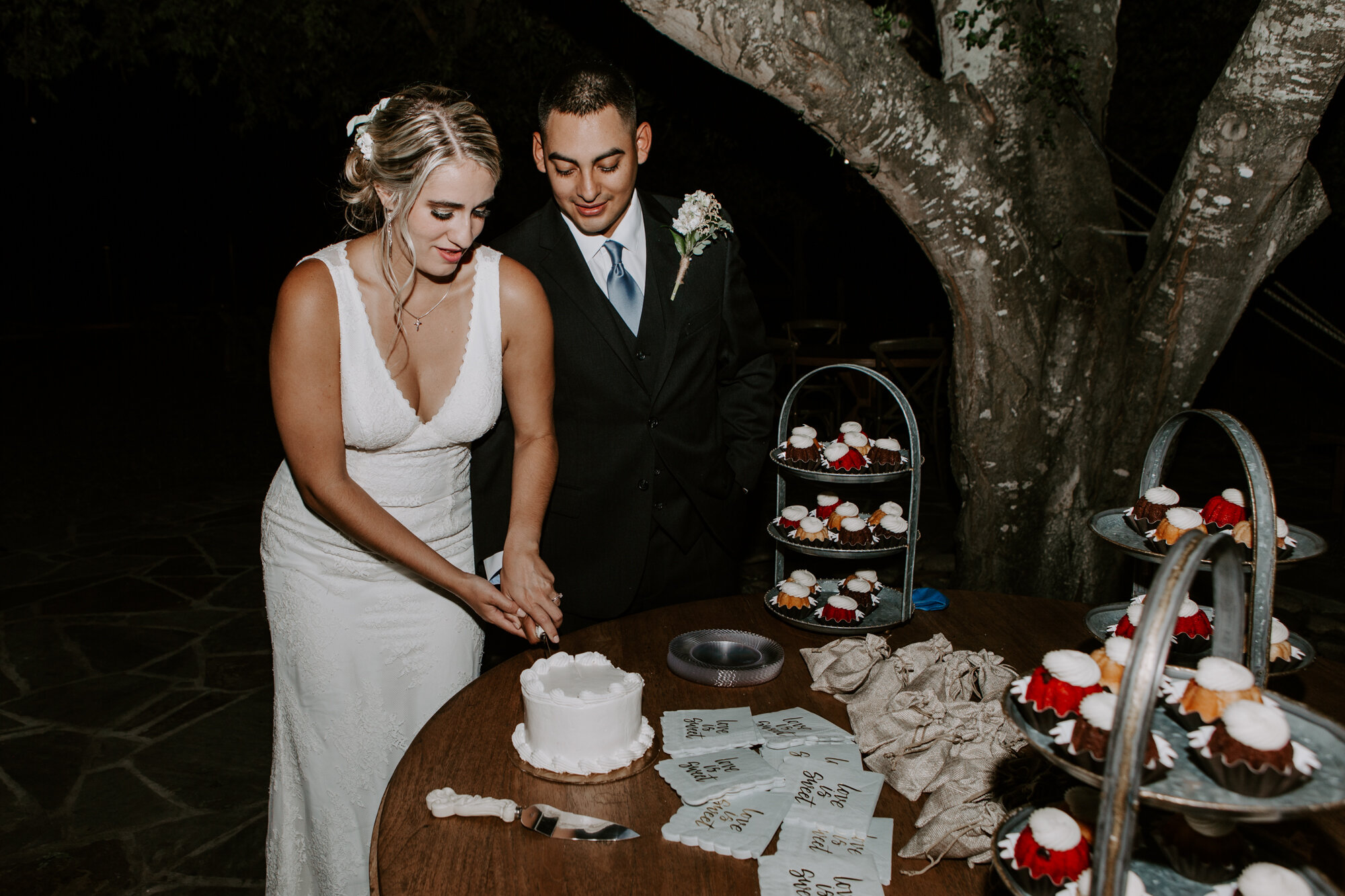 Bride and groom cake cutting. Radiant Bohemian Hill Country Wedding at Gruene Estate in New Braunfels, TX