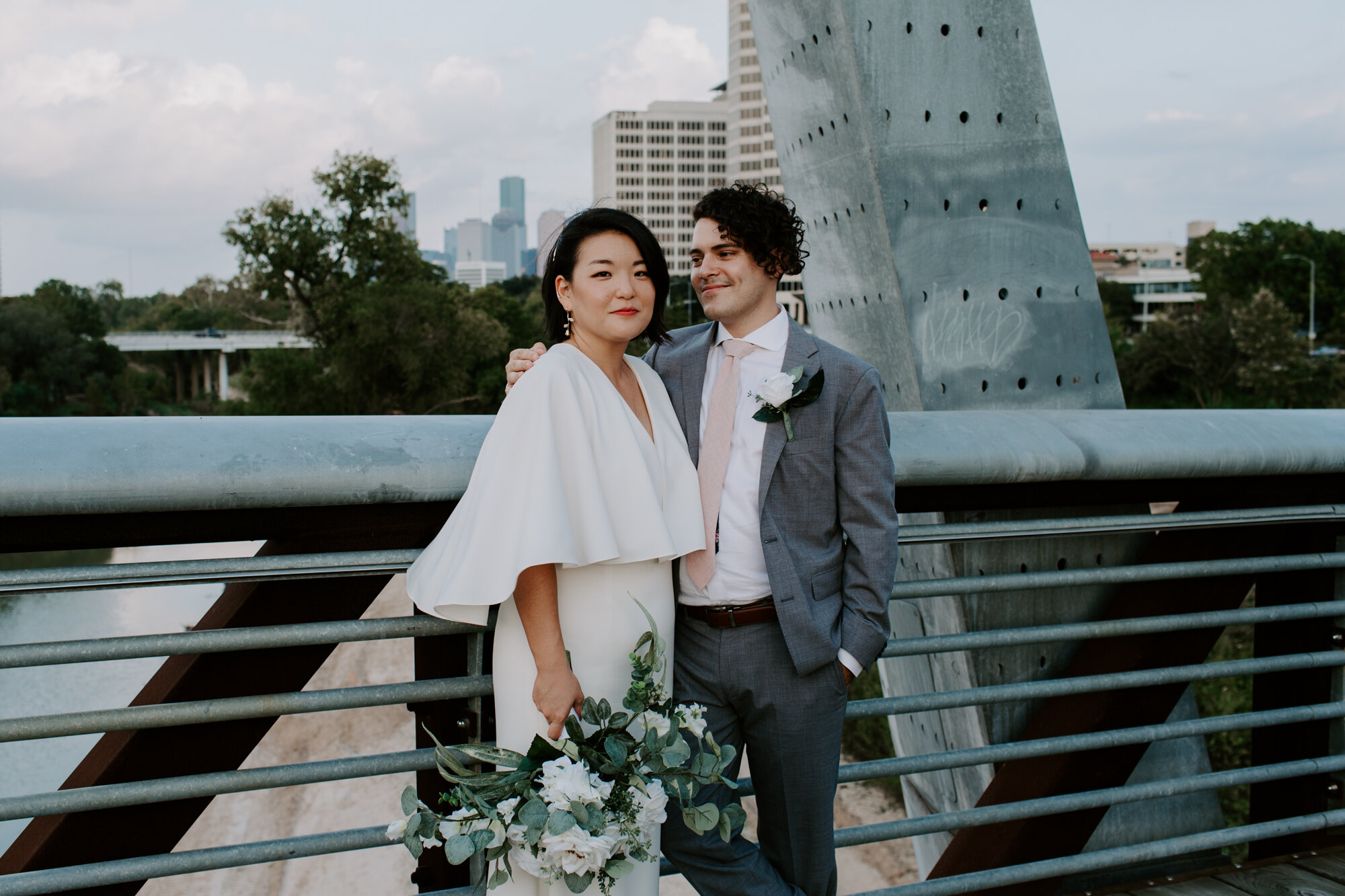 Skyline view. Bride and Groom Wedding Photo Session at The Lost Lake Buffalo Bayou Park