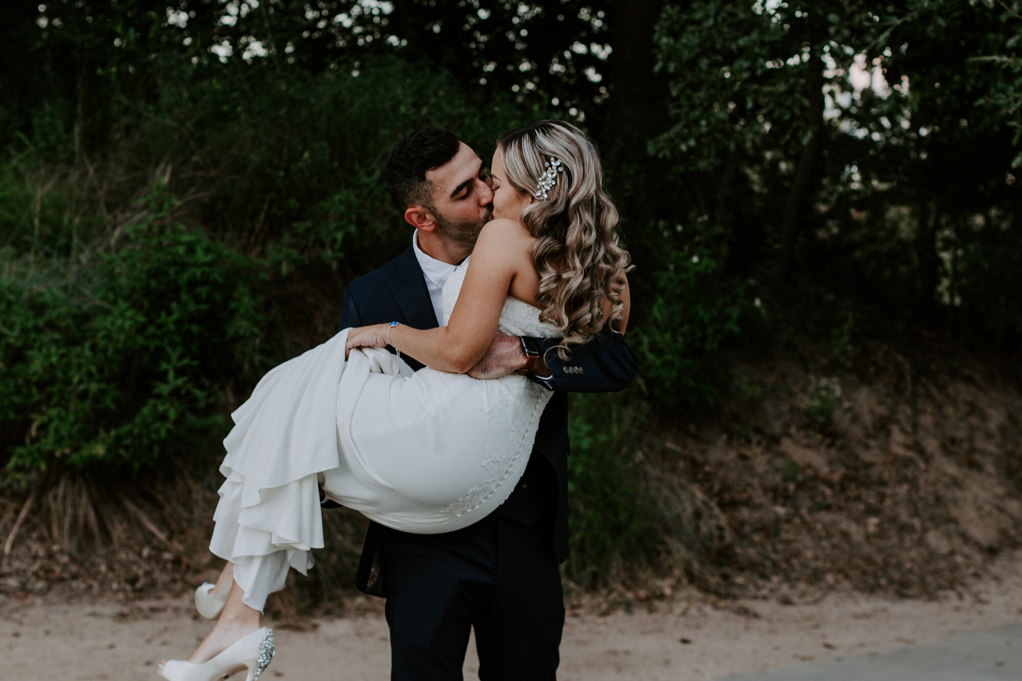 Groom carries bride. Glamorous Wedding at The Dunlavy and the Lost Lake Buffalo Bayou Park