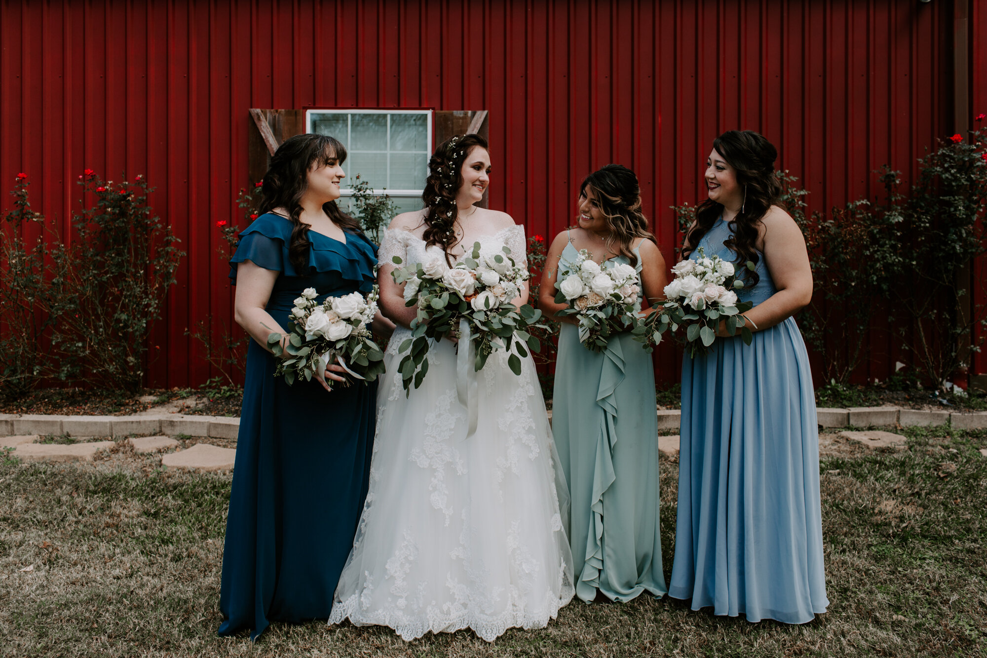 Bride and bridesmaids by the red wall. Fairy Romantic Wedding at Magnolia Bells in Magnolia, TX