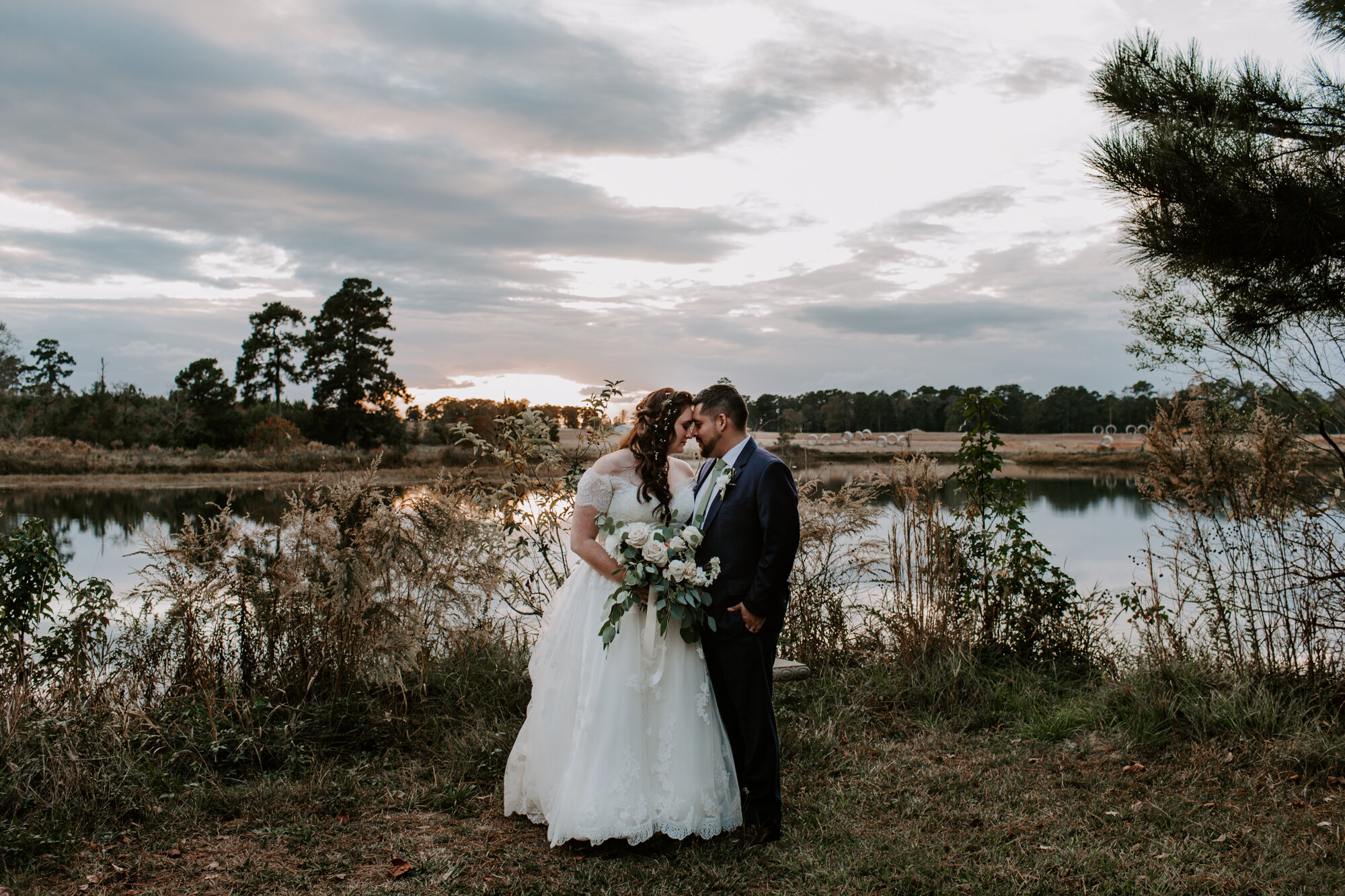 Bride and groom sunset portraits by the lake. Fairy Romantic Wedding at Magnolia Bells in Magnolia, TX