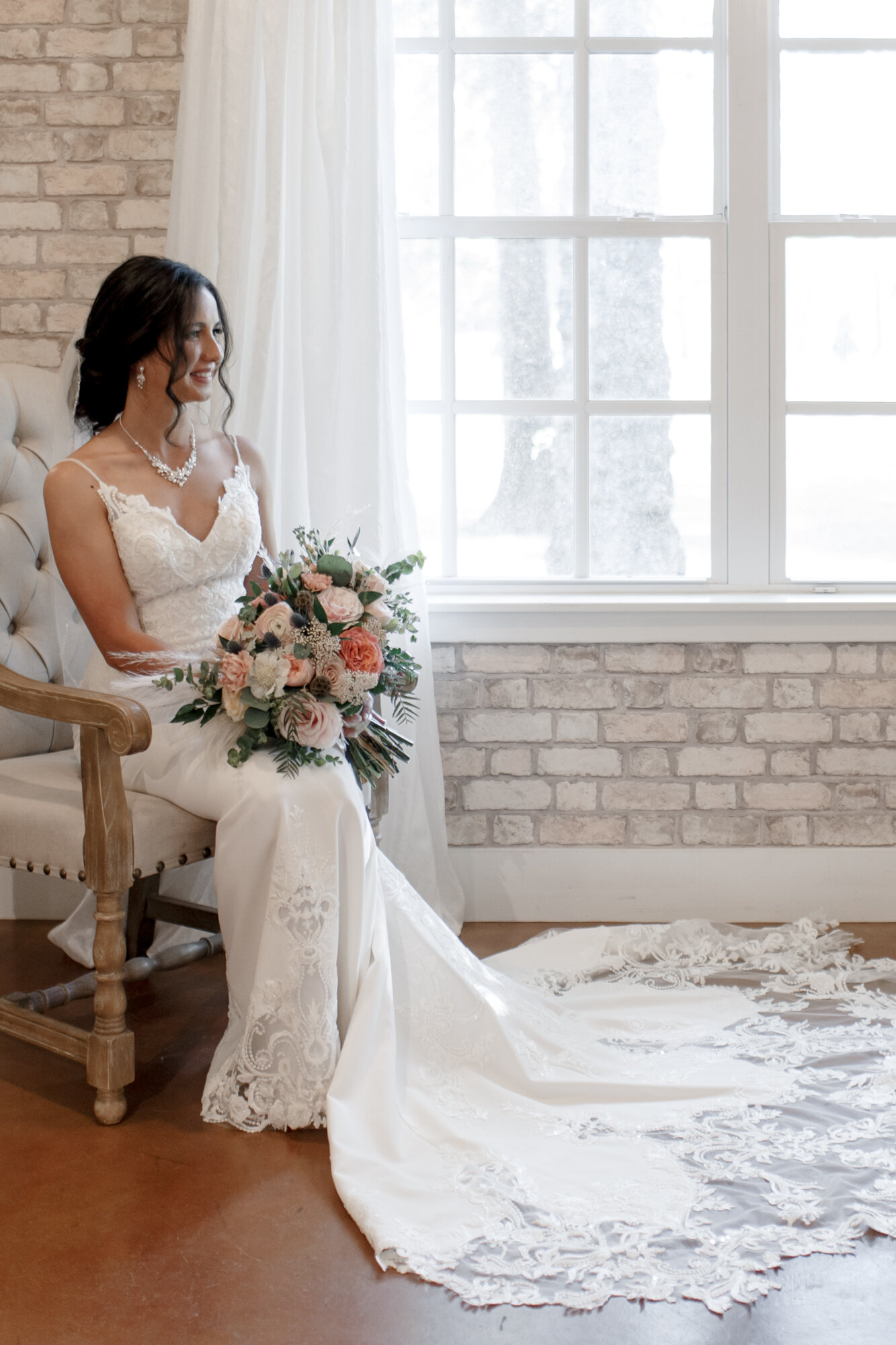Bride sitting by the window. Romantic Chic Country Wedding at Rustic Luxury Balmorhea Events&nbsp;Venue in Magnolia, TX