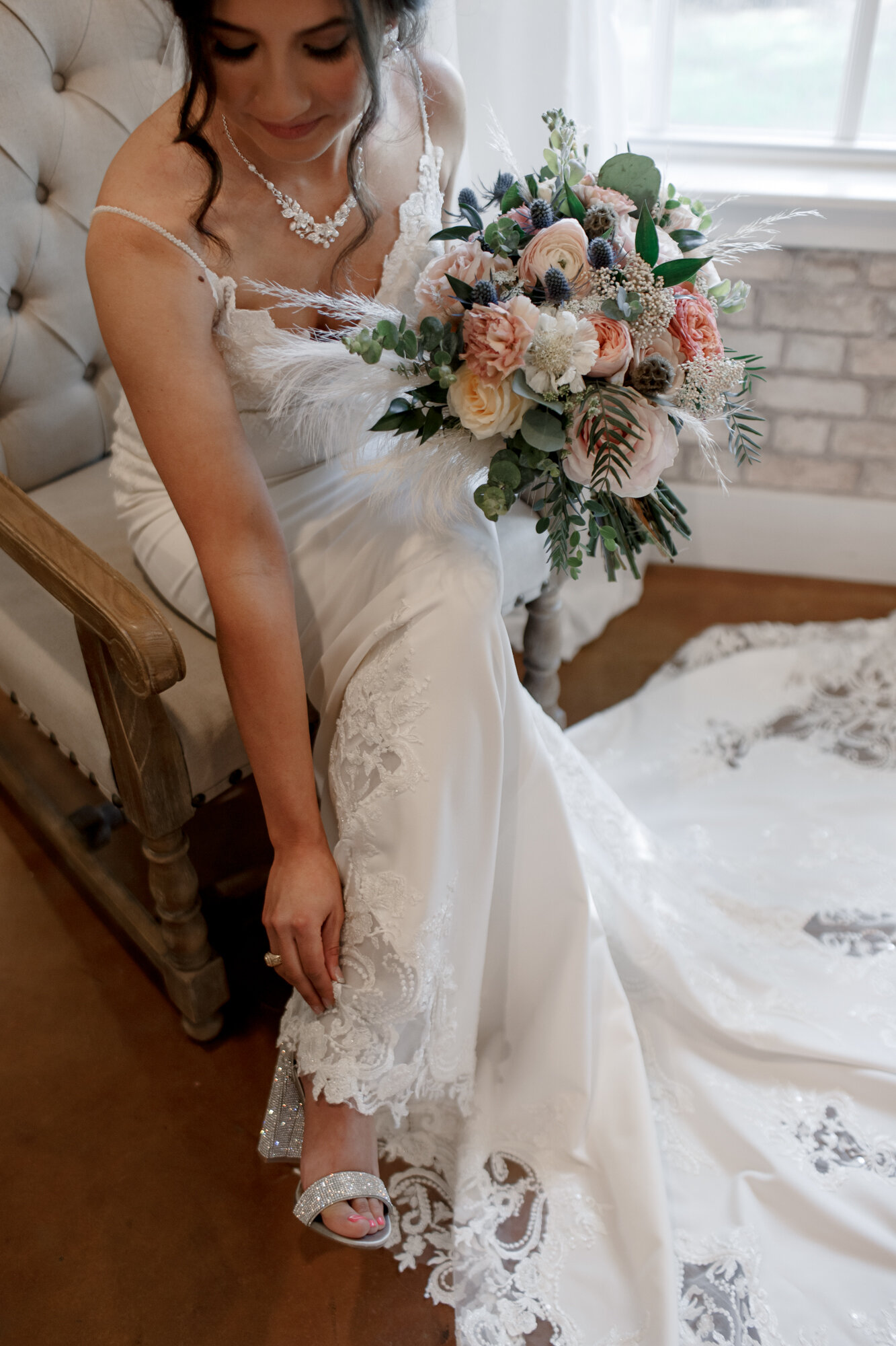 Bride fixing her sparkly shoe. Romantic Chic Country Wedding at Rustic Luxury Balmorhea Events&nbsp;Venue in Magnolia, TX