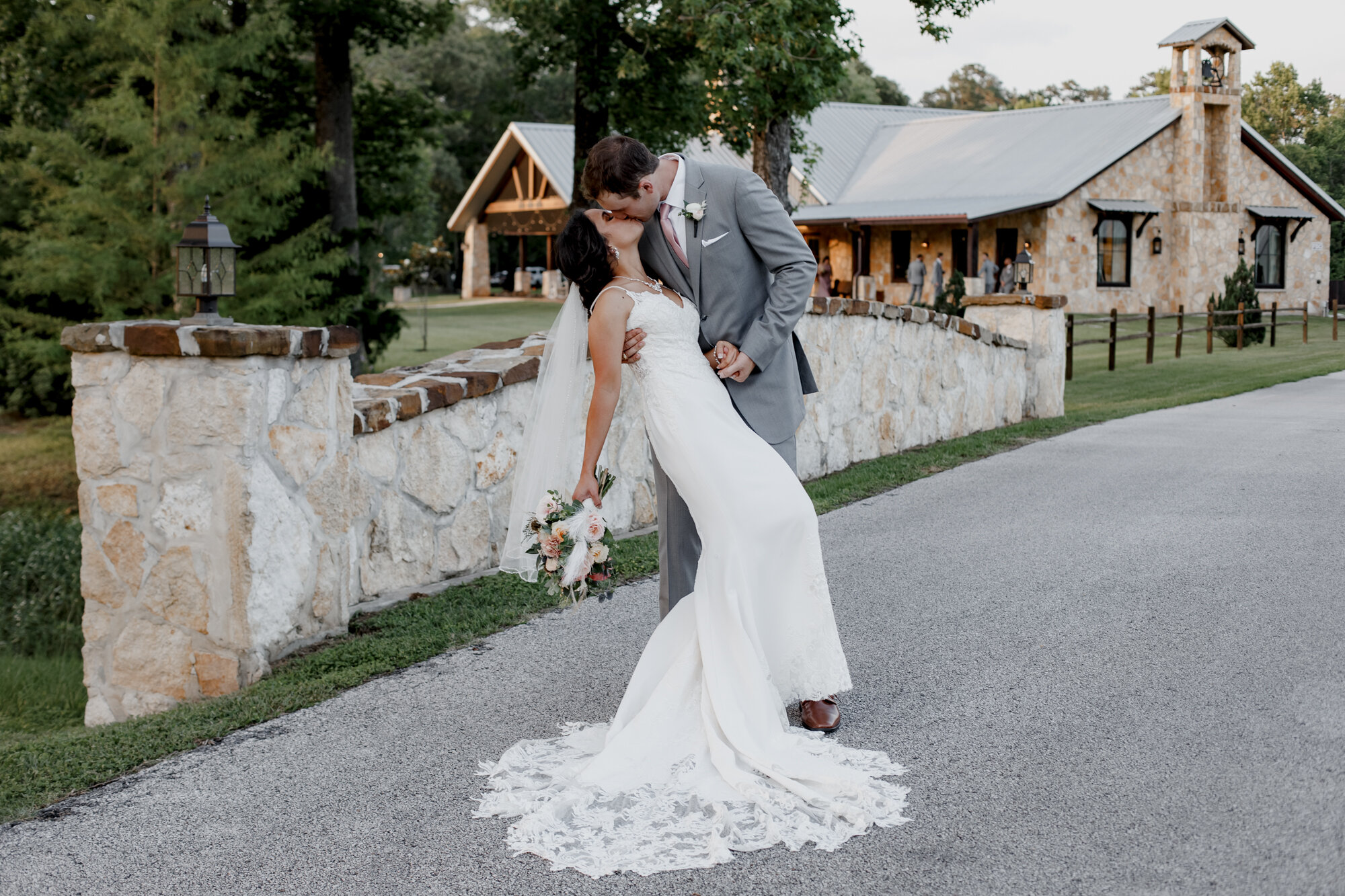 Bride and groom kissing on the bridge. Romantic Chic Country Wedding at Rustic Luxury Balmorhea Events&nbsp;Venue in Magnolia, TX