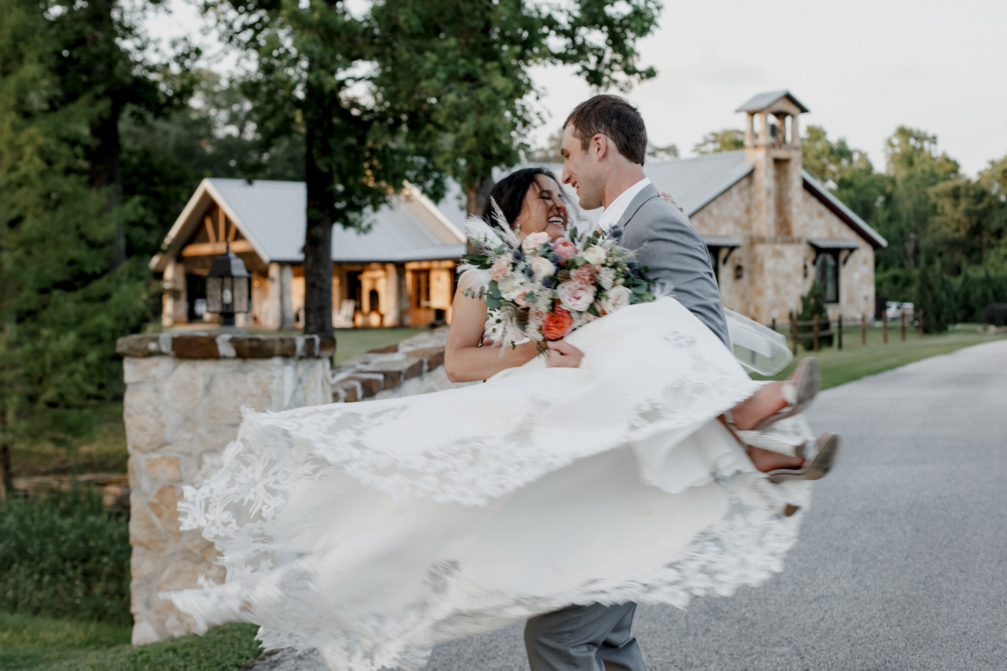 Groom holding bride and spinning. Romantic Chic Country Wedding at Rustic Luxury Balmorhea Events&nbsp;Venue in Magnolia, TX