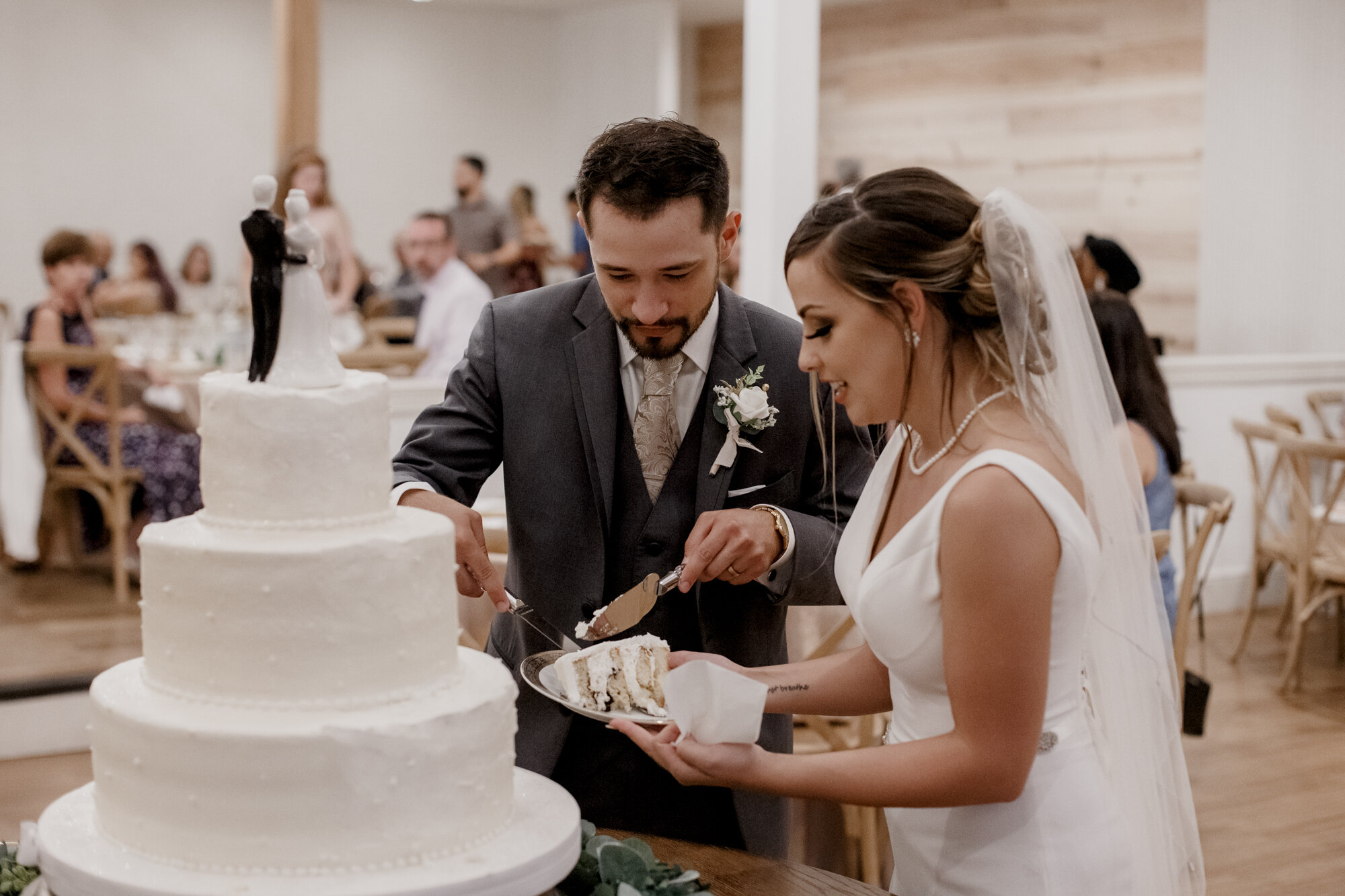 Bride and groom cutting the cake. Glowing Wedding in Golden Champagne Tones at The Orchard at Caney Creek in Wharton, TX