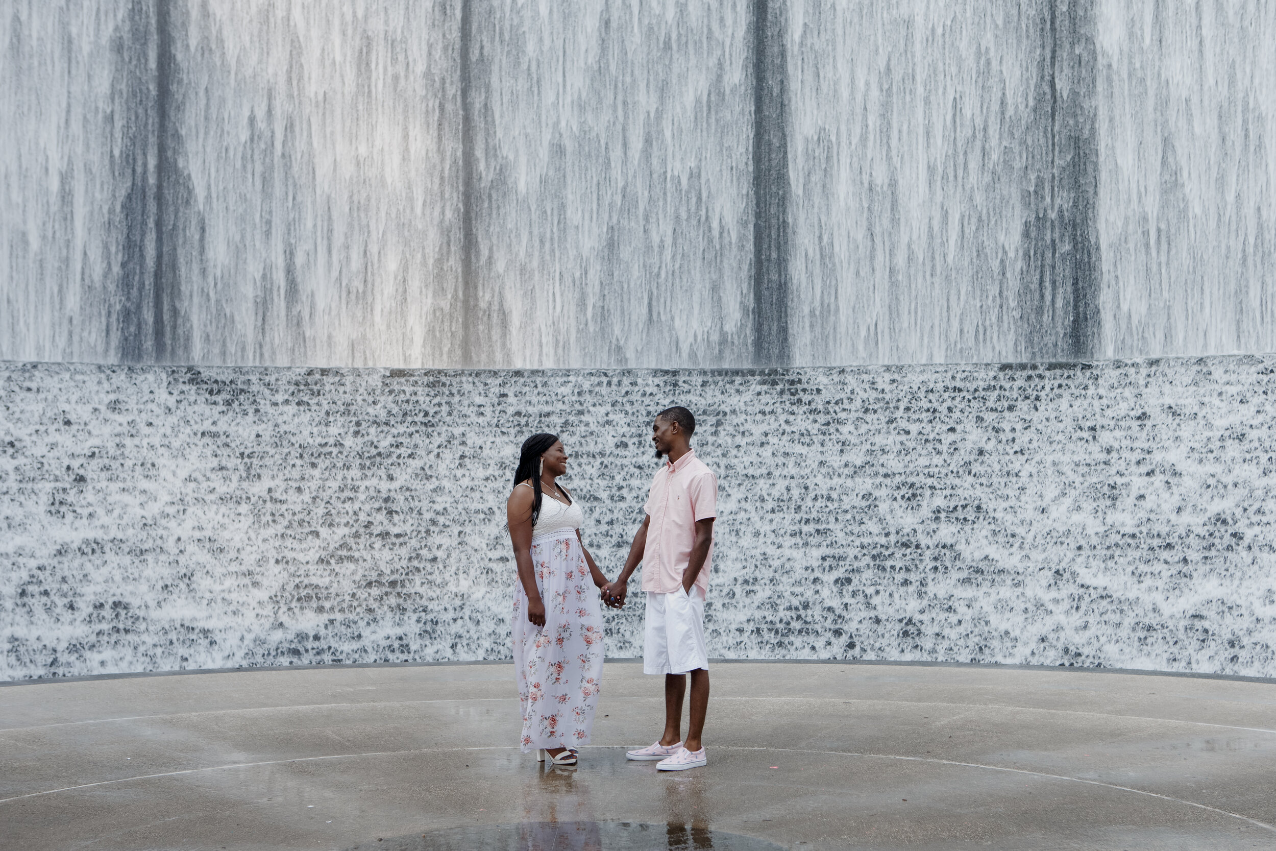 Couple standing by the waterfall. Early Morning Engagement Photo Session at Waterwall Place