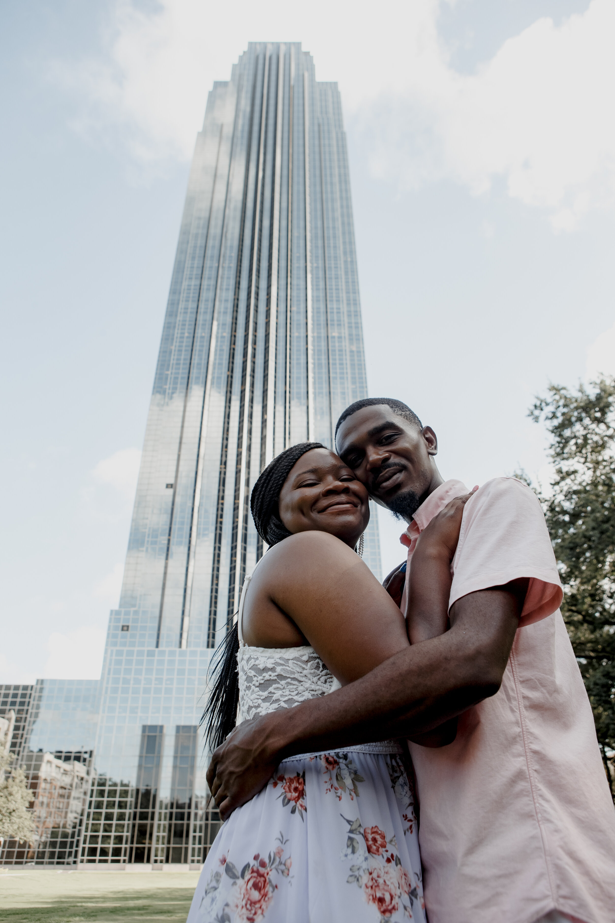 Couple hugs by the Williams tower. Early Morning Engagement Photo Session at Waterwall Place