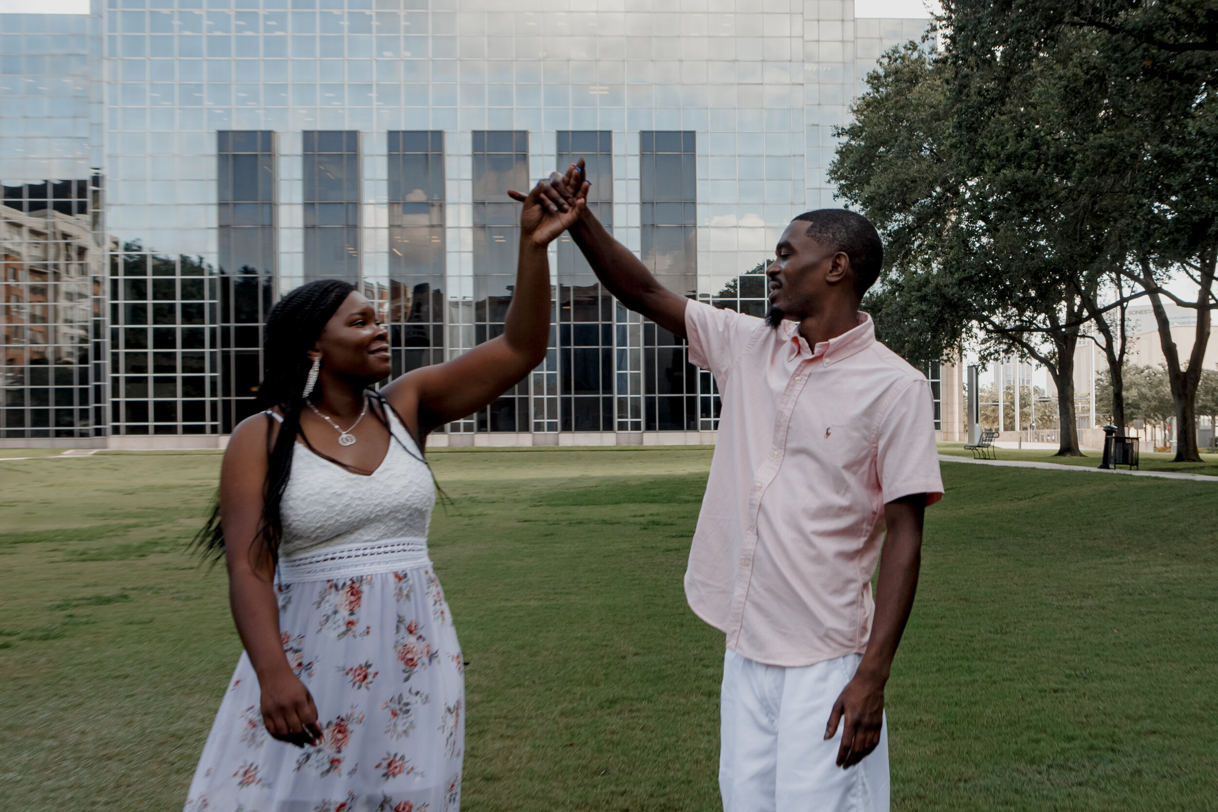 Couple dancing by the Williams tower. Engagement Photo Session at WaterEarly Morning Engagement Photo Session at Waterwall Placewall Place (Houston, TX)