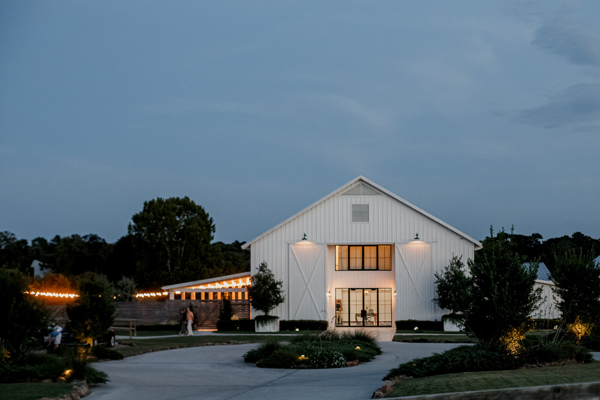 Night shot of the venue with the light on. Burnt Orange and Black Fall Wedding at The Farmhouse