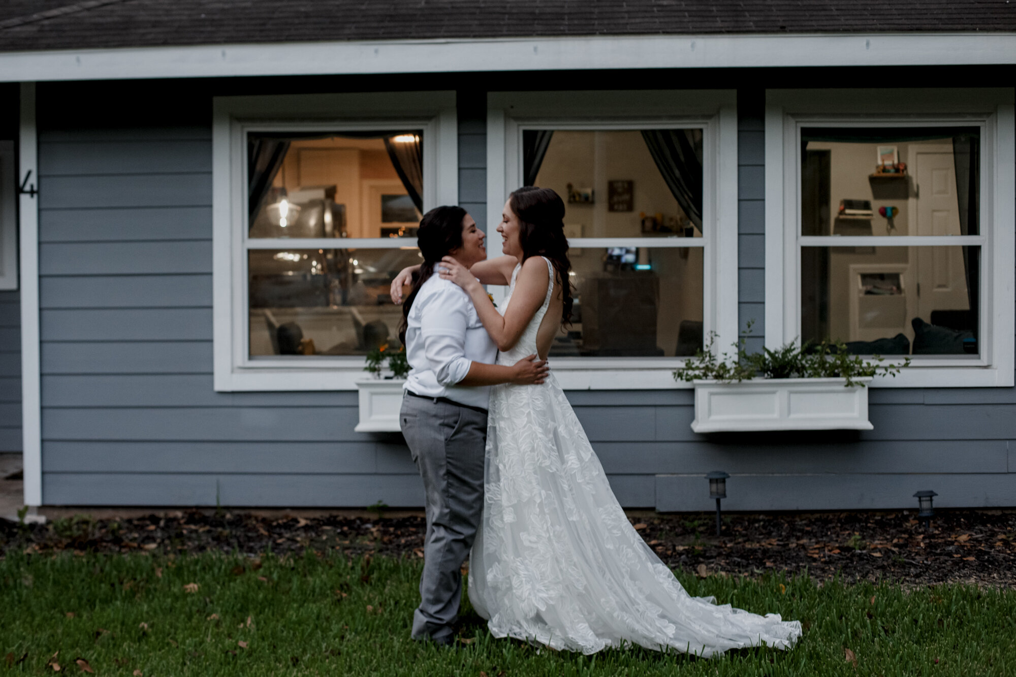 Cozy Laid-Back LGBTQ+ Backyard Wedding. Brides portraits in front of the house.