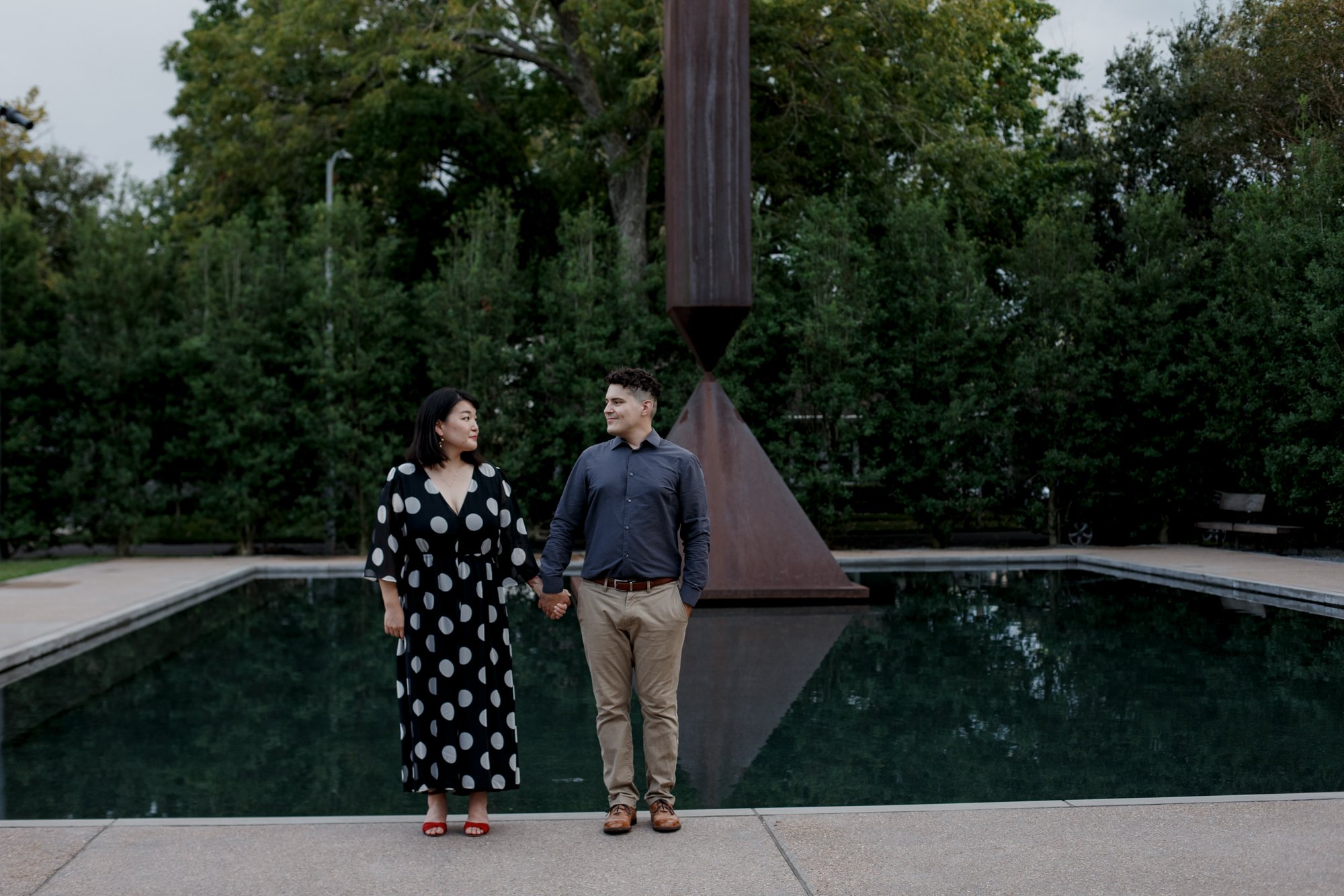 Couple posing hand in hand - Stylish Polka Dot Dress Engagement Photo Session by Rothko Chapel Sculpture