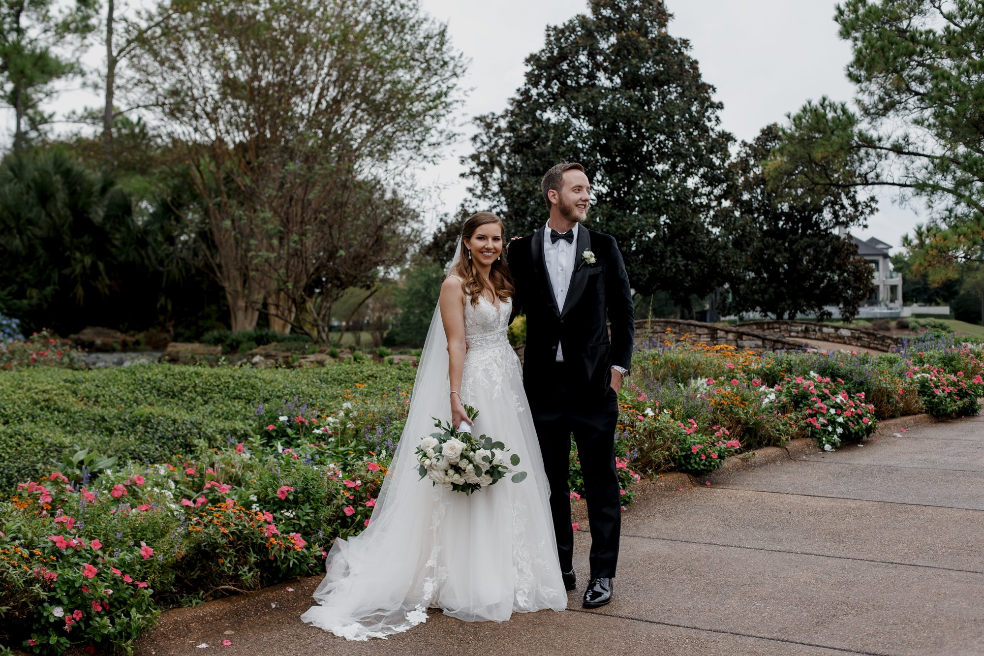 Bride and groom posing by the flowers. Wedding at Royal Oaks Country Club