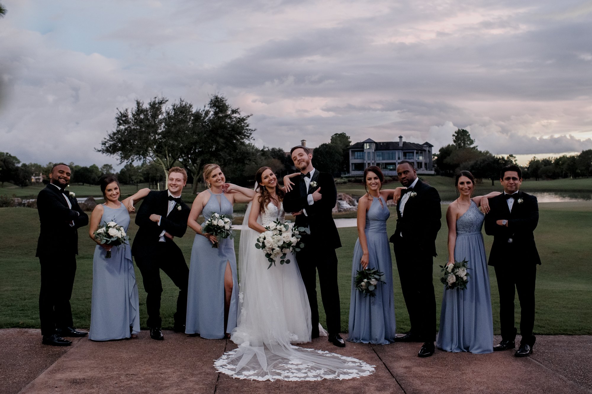 Bride and groom with bridal party sassy poses. Wedding at Royal Oaks Country Club