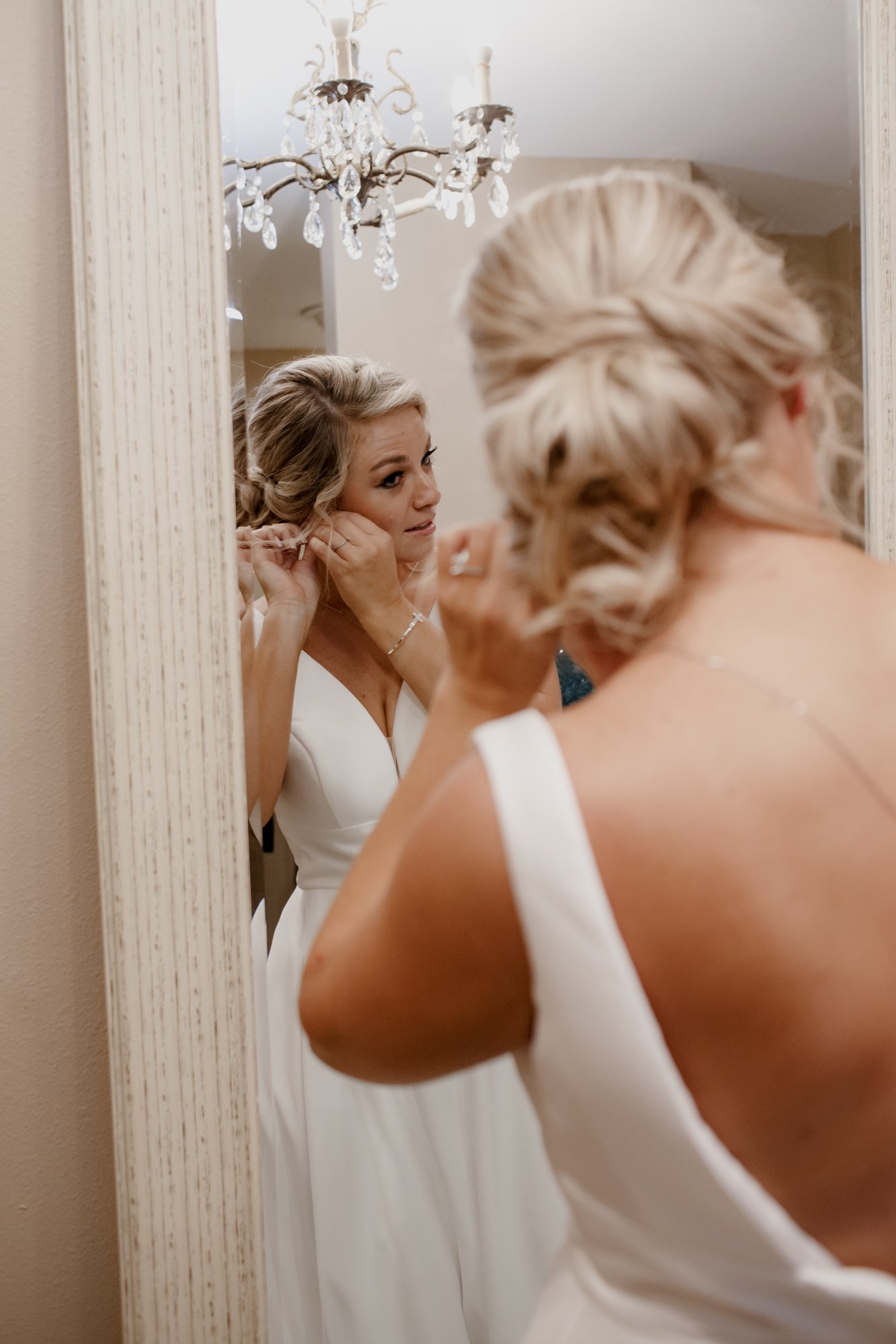 Preparations bride getting ready putting earring on. Wedding at Shirley Acres (Houston, TX)