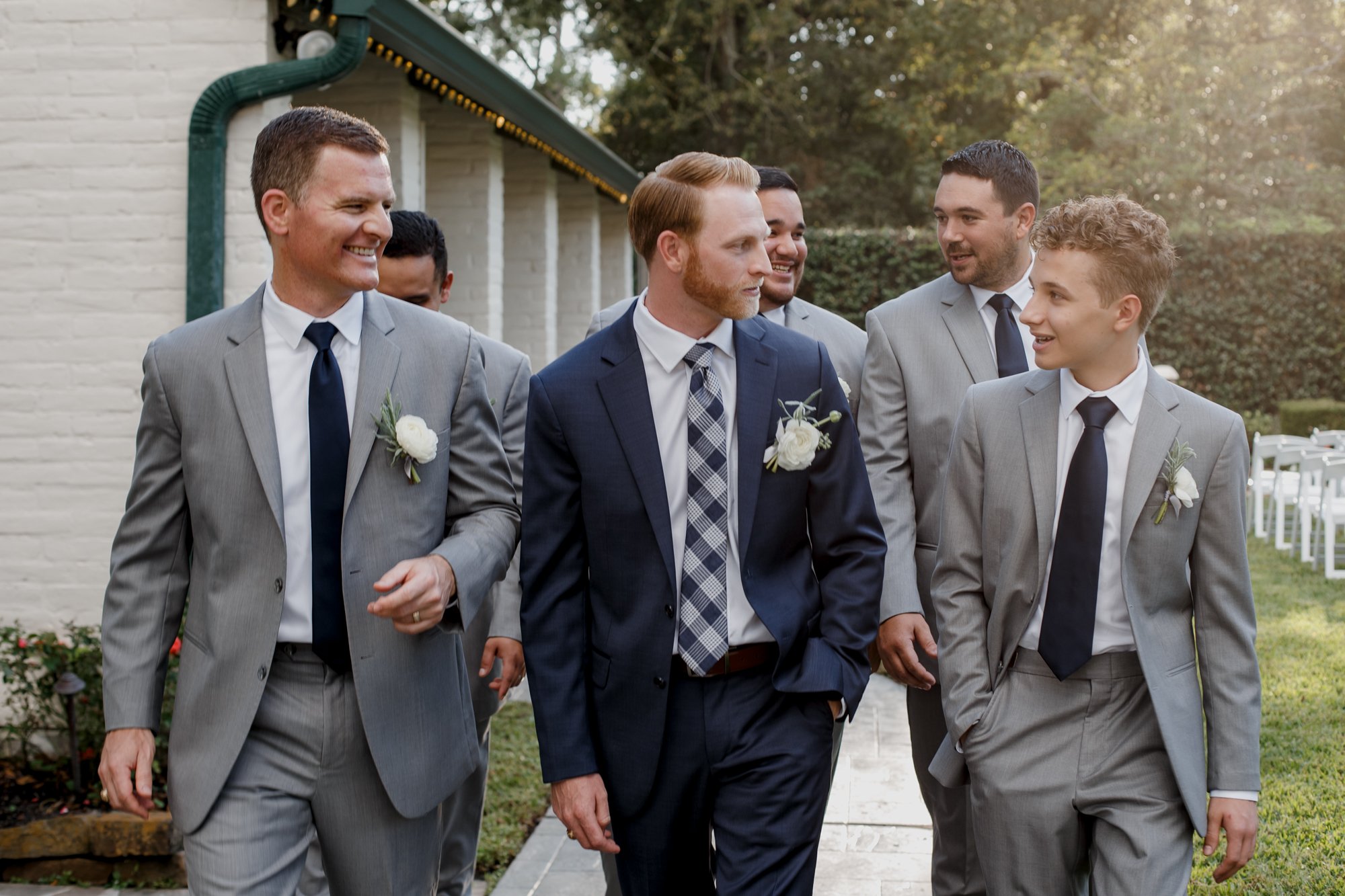 Groom and groomsmen portraits walking looking at each other. Wedding at Shirley Acres