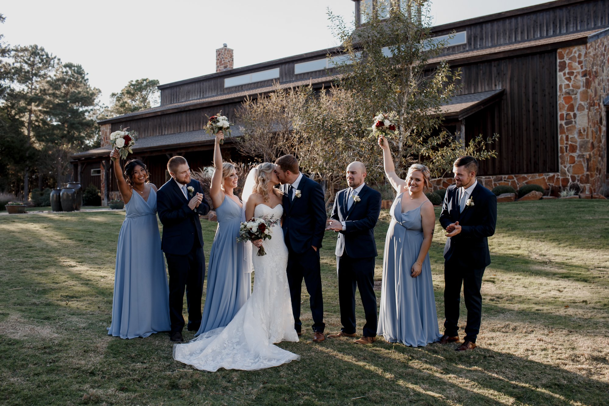 Bride and groom posing with bridal party. Wedding at The Vine (New Ulm, TX)