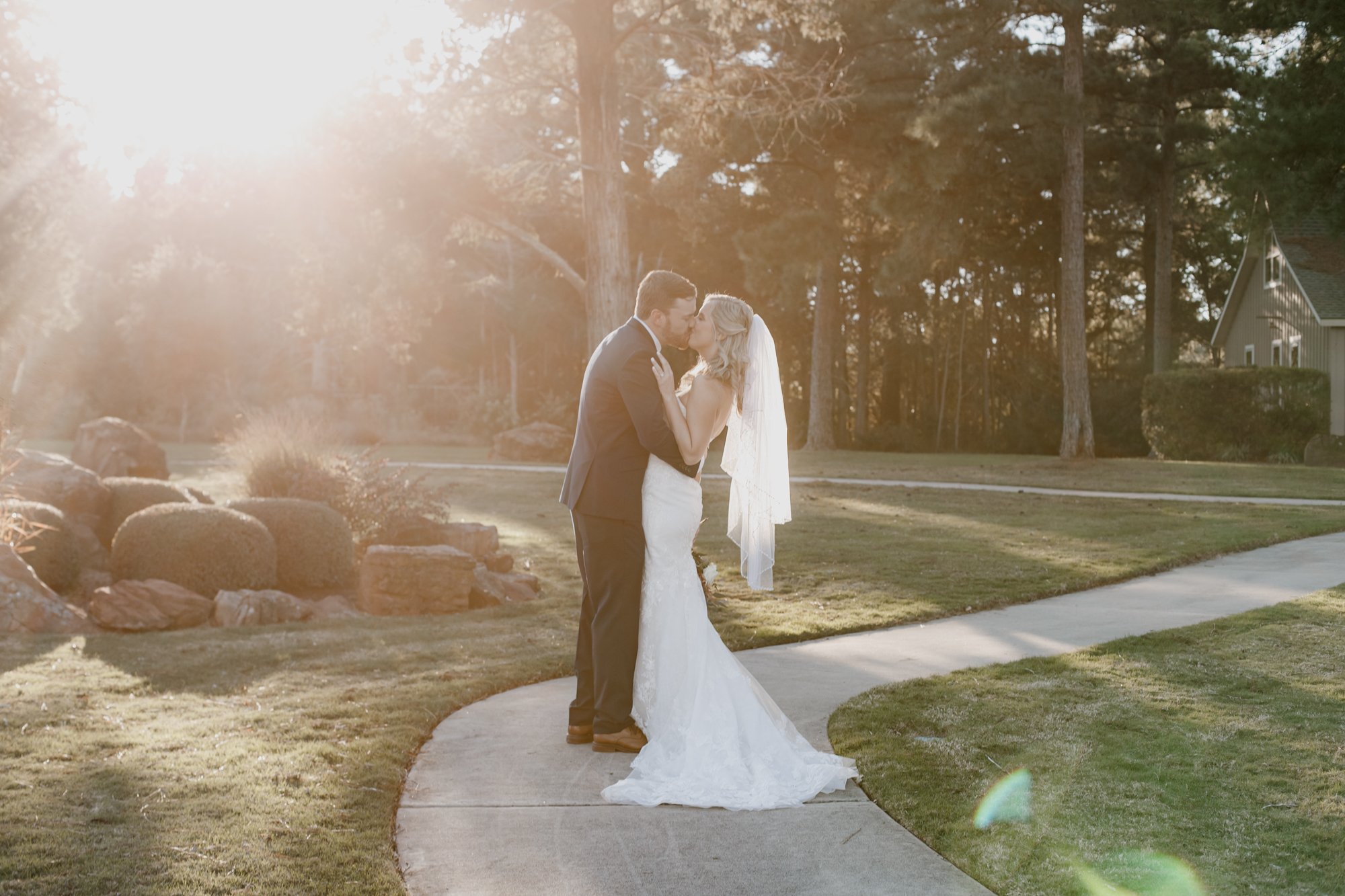 Bride and groom kiss in sunlight - golden hour portraits. Wedding at The Vine (New Ulm, TX)