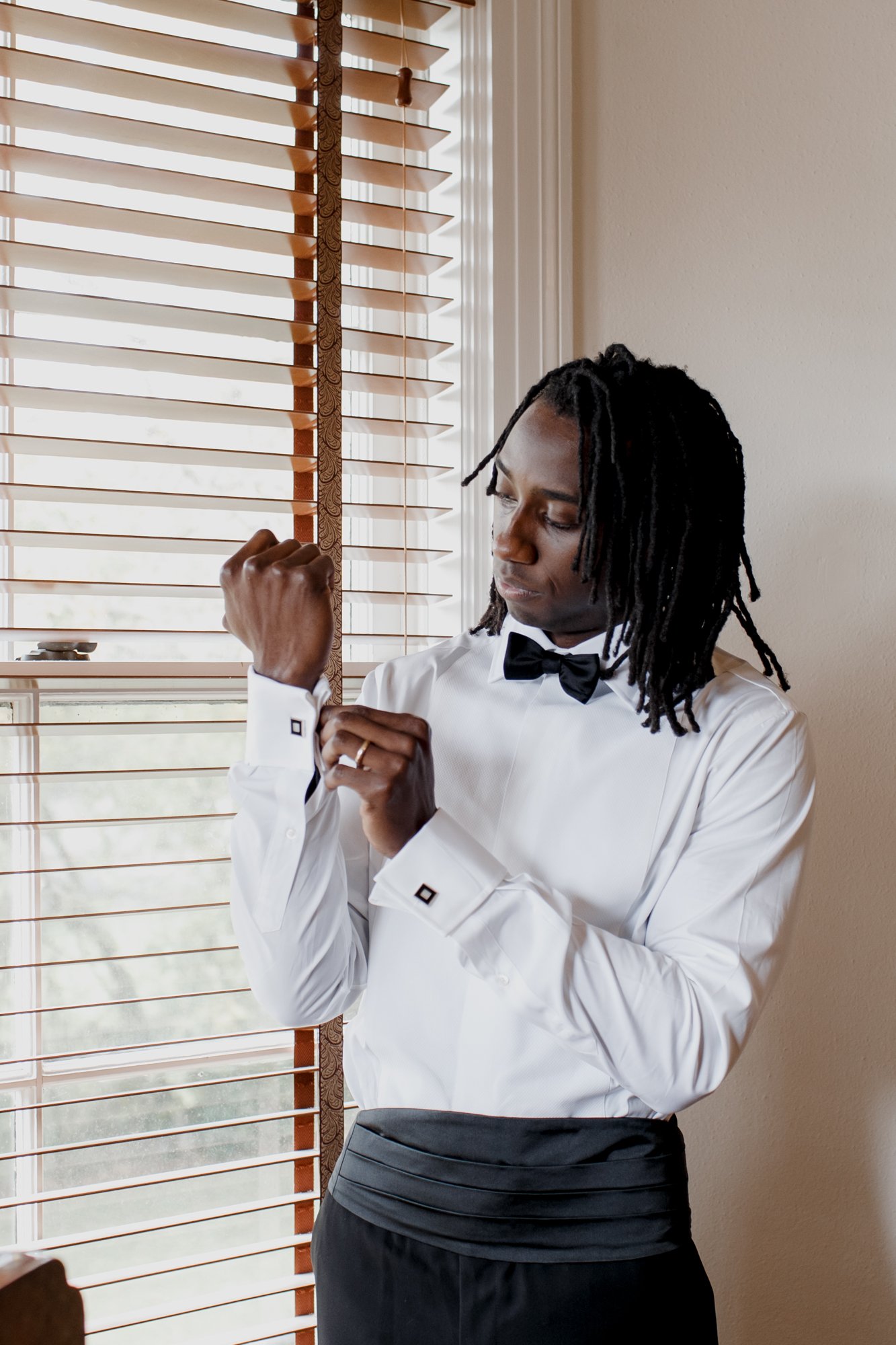 Private house preparations groom getting ready by the window. New Orleans Style Wedding at McGovern Centennial Gardens