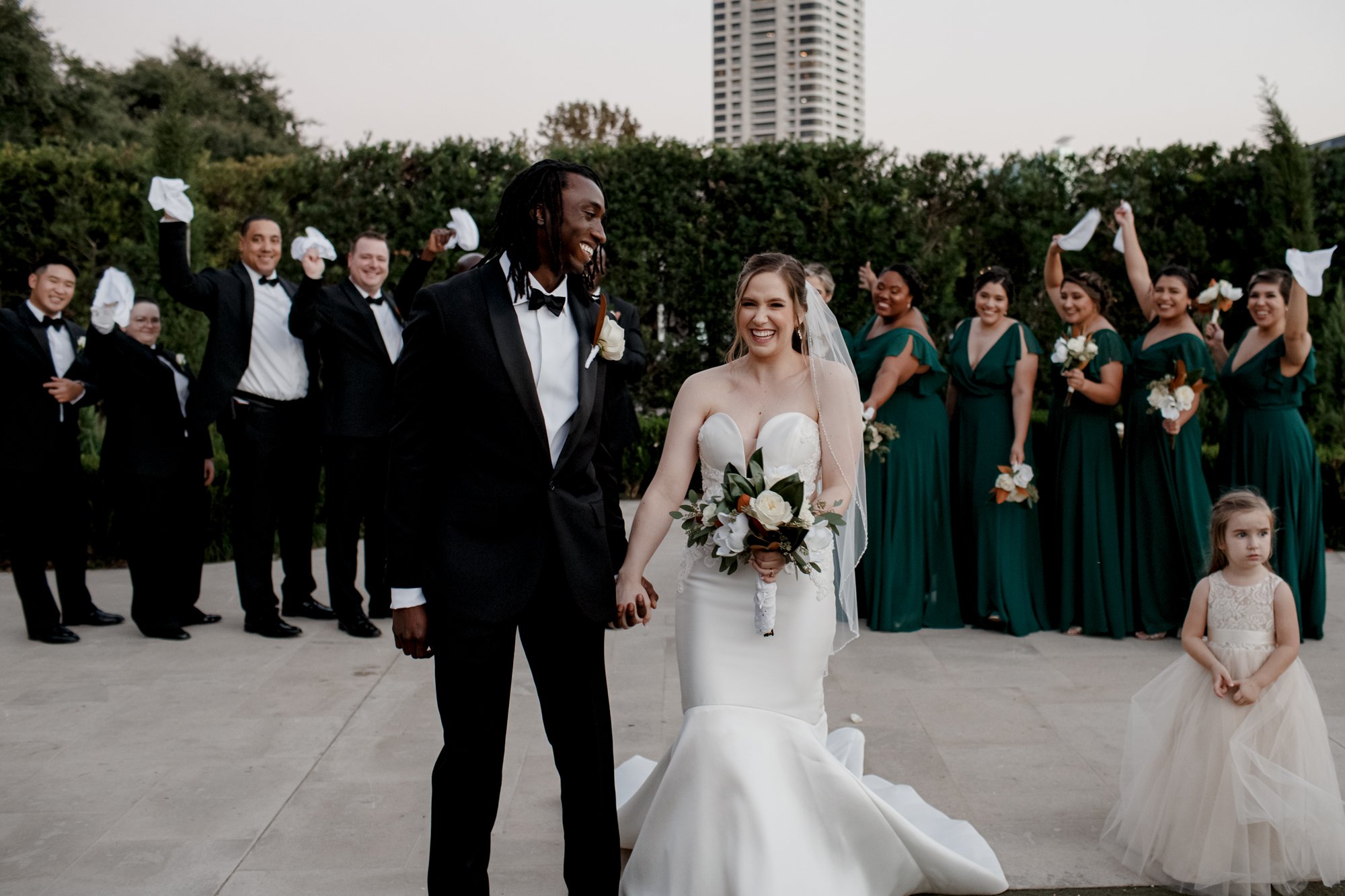Bride and groom kiss, bridal party cheer. New Orleans Style Wedding at McGovern Centennial Gardens