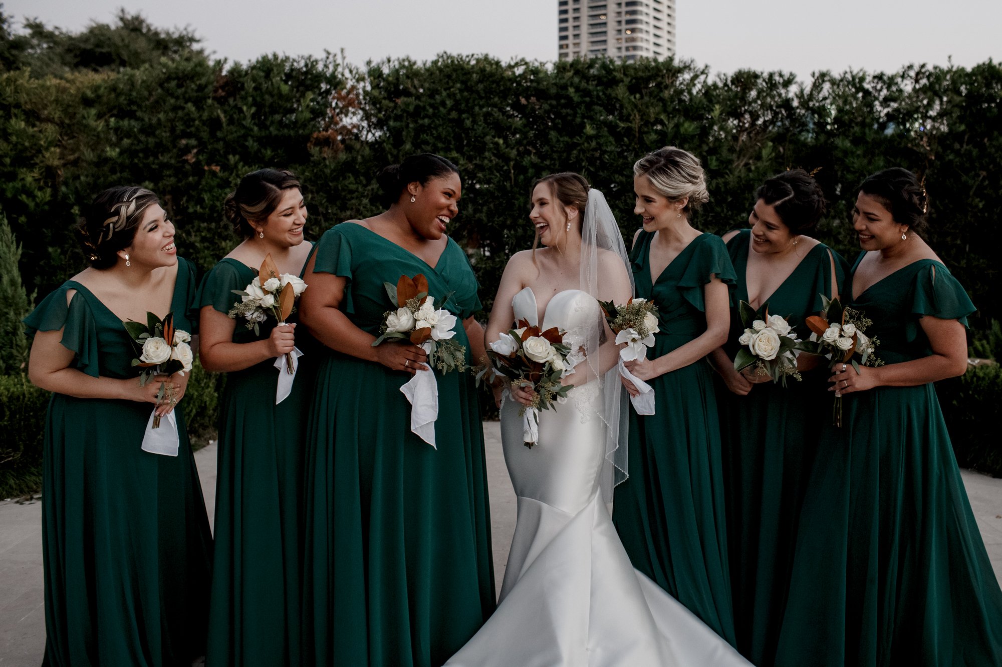 Bride and bridesmaids looking at each other smiling. New Orleans Style Wedding at McGovern Centennial Gardens