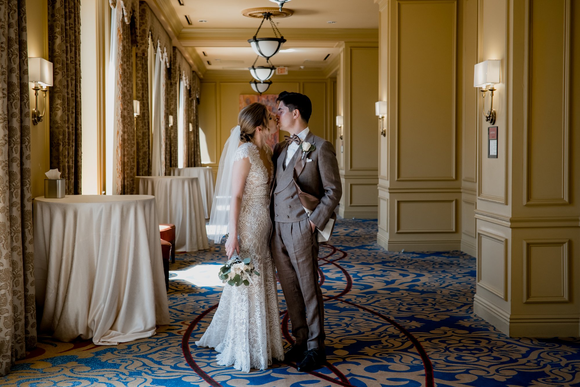 Bride and groom kiss in a hallway. Wedding at Hotel Icon