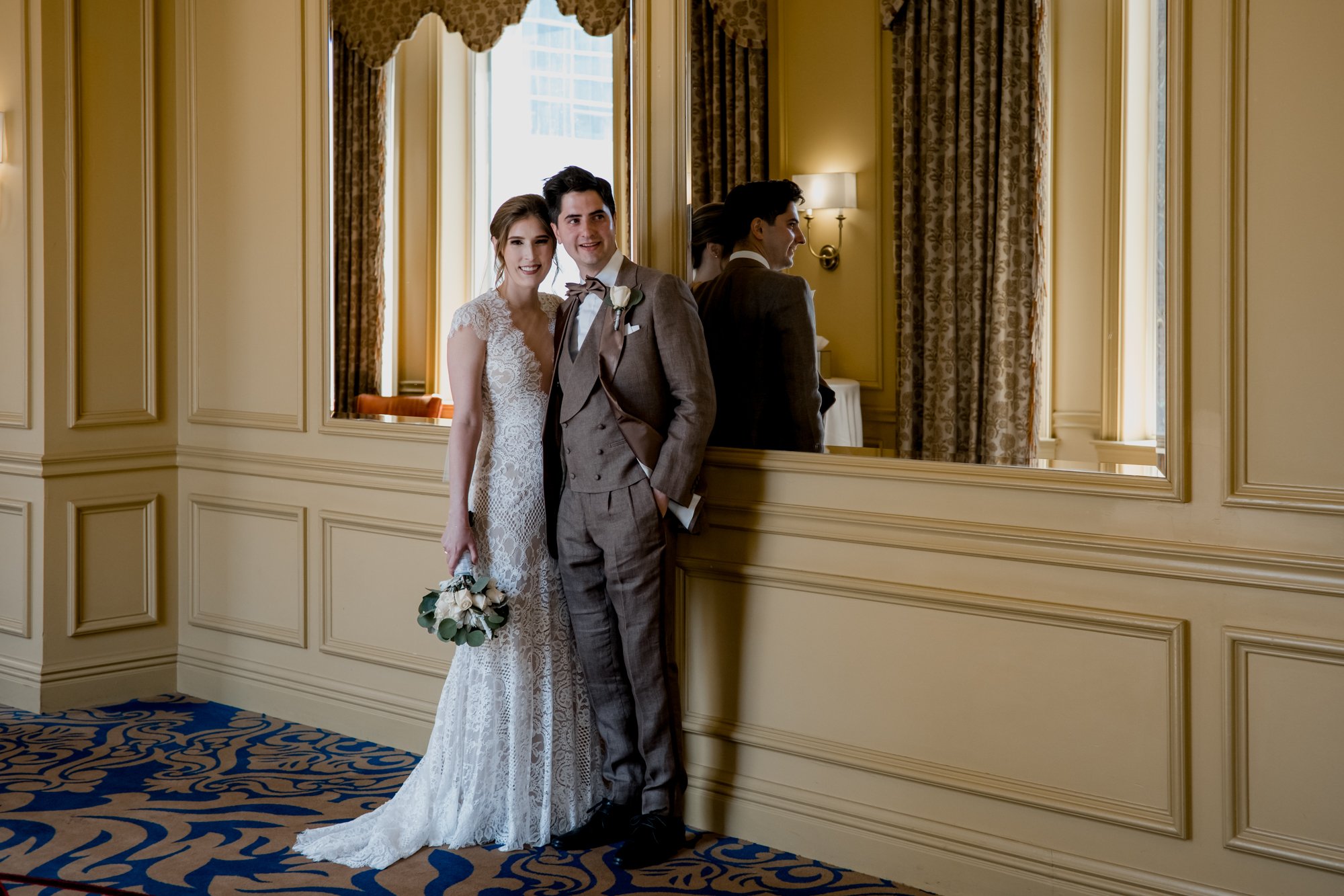 Bride and groom pose by the mirror. Wedding at Hotel Icon