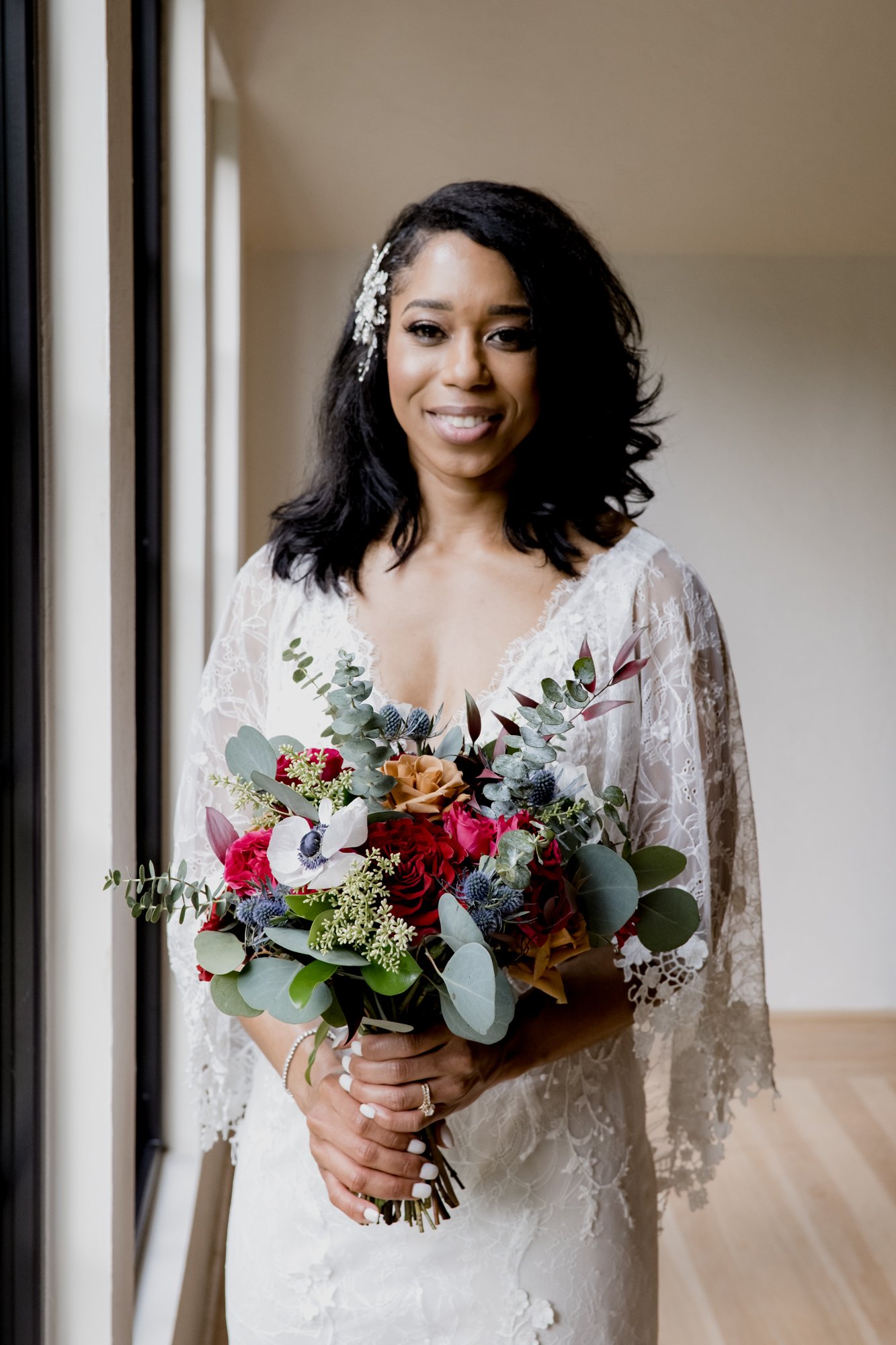 Bridal portraits, bride holding the bouquet next to the window. Wedding at The Oak Atelier