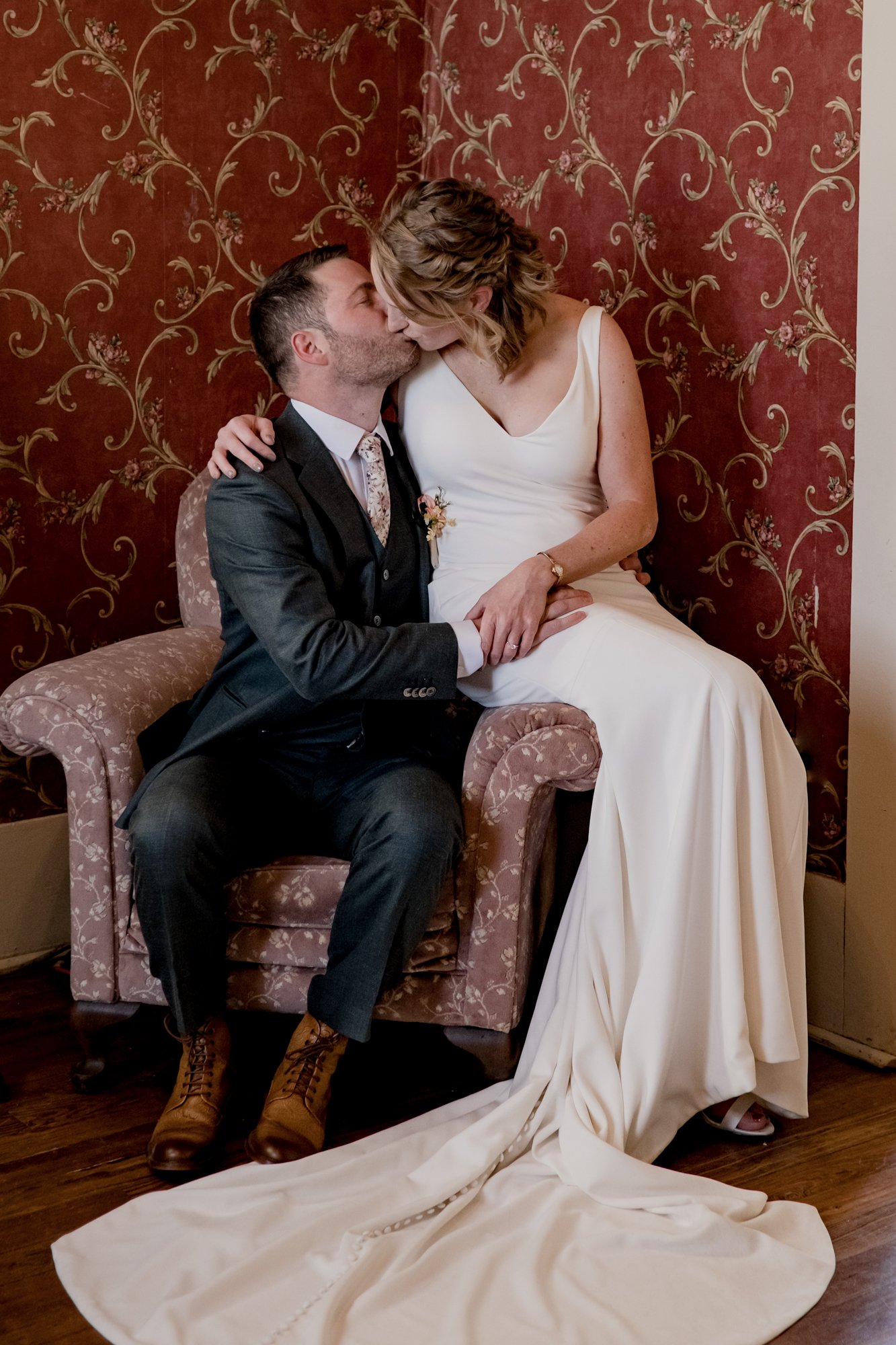 Bride and groom kissing in the armchair Wedding at Antique Rose Emporium