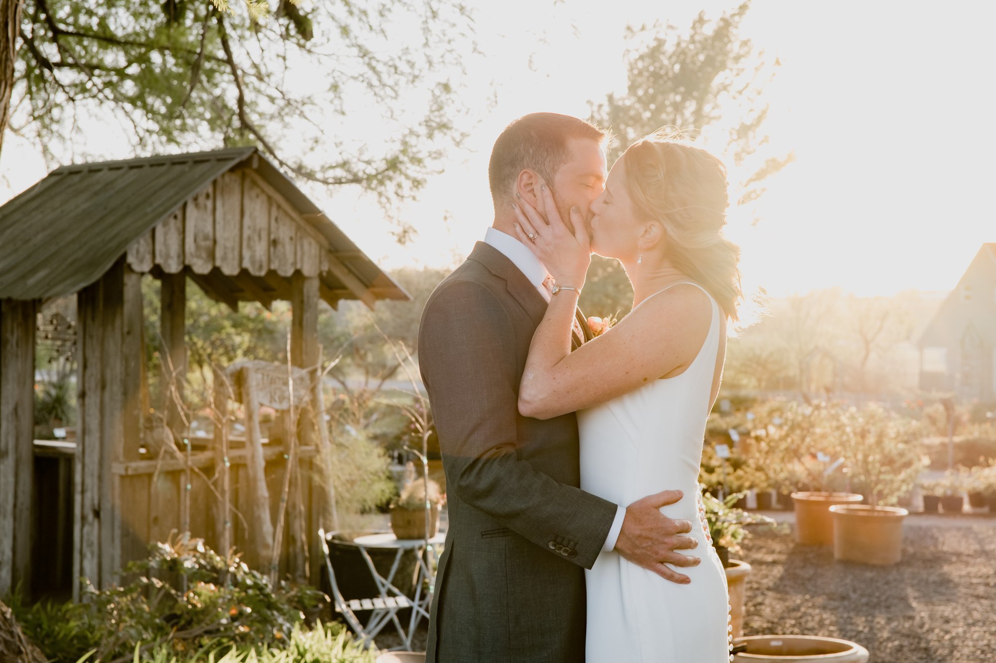 Bride and groom kissing in a sunlight golden hour. Wedding at Antique Rose Emporium