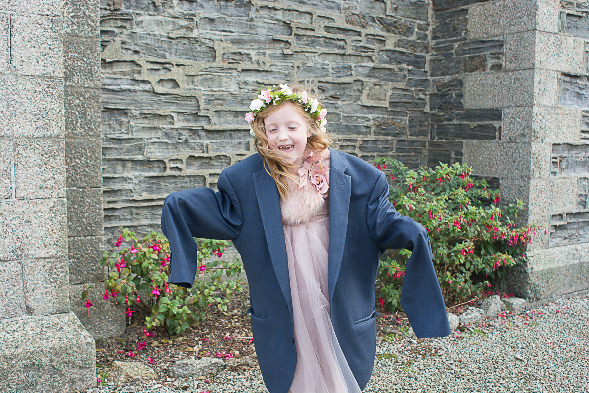 adorable flowergirl with her dads jacket on in porthleven