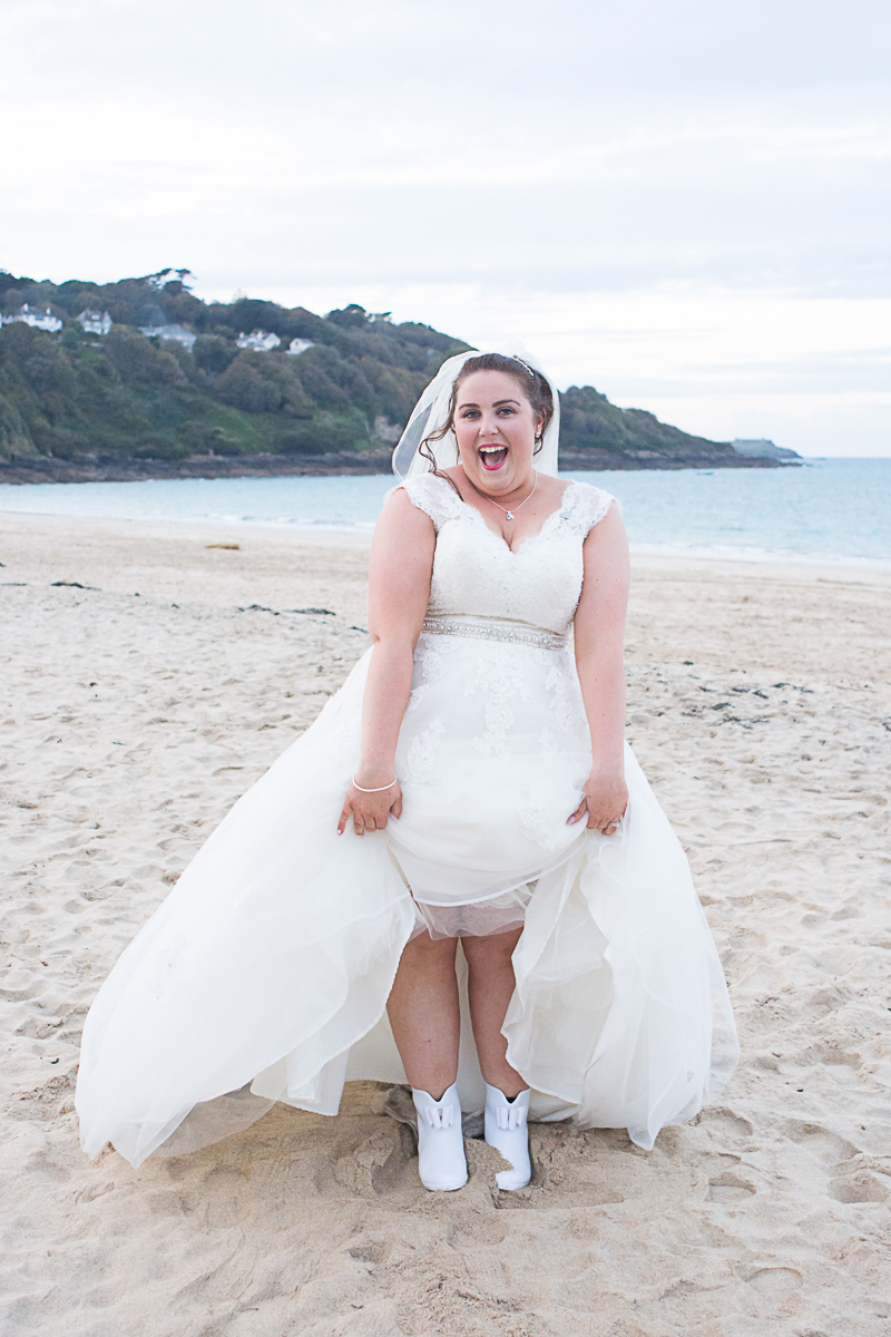 bride with wellies on the beach at carbis bay cornwall