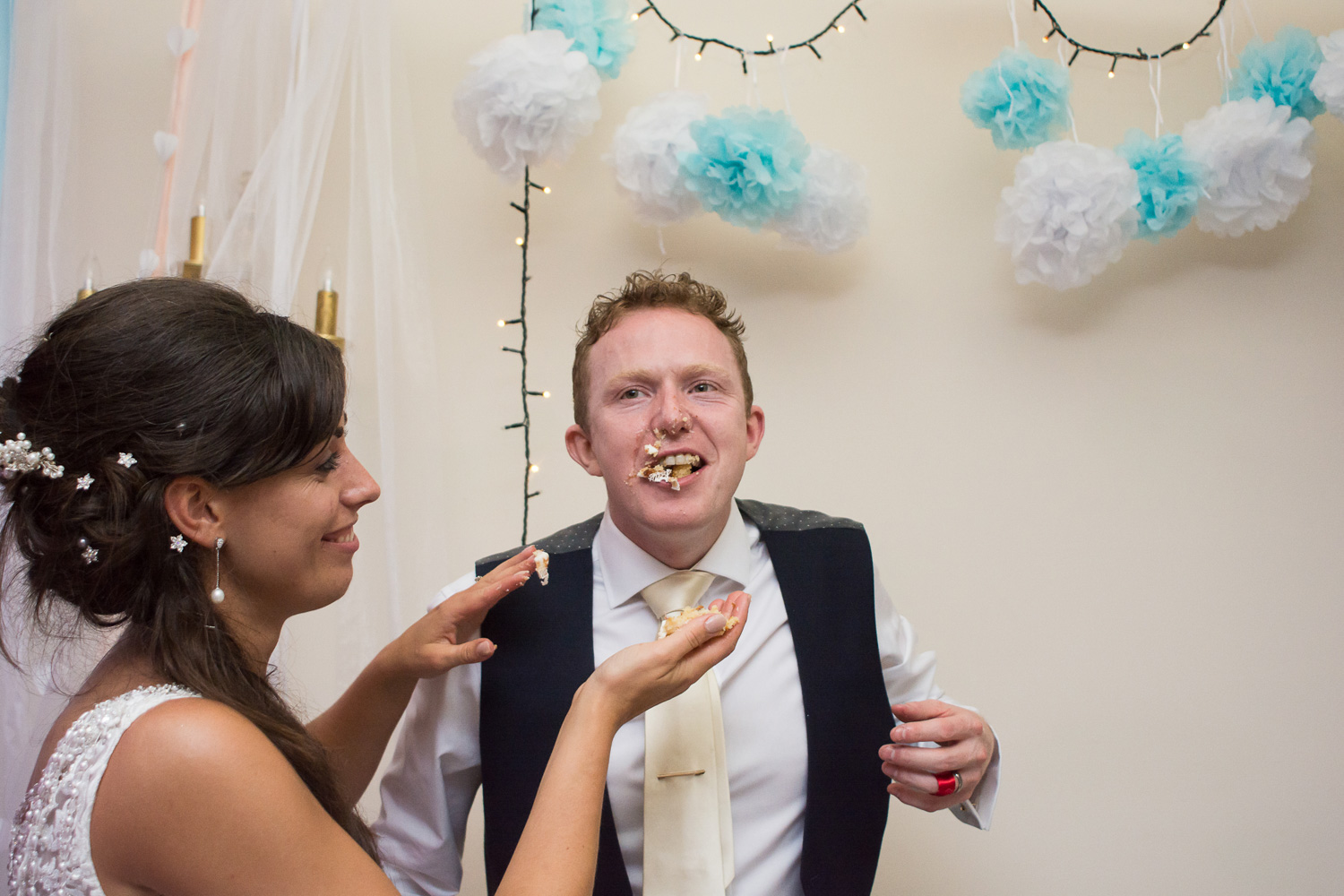 cake cutting gets messy at Boringdon Hall wedding