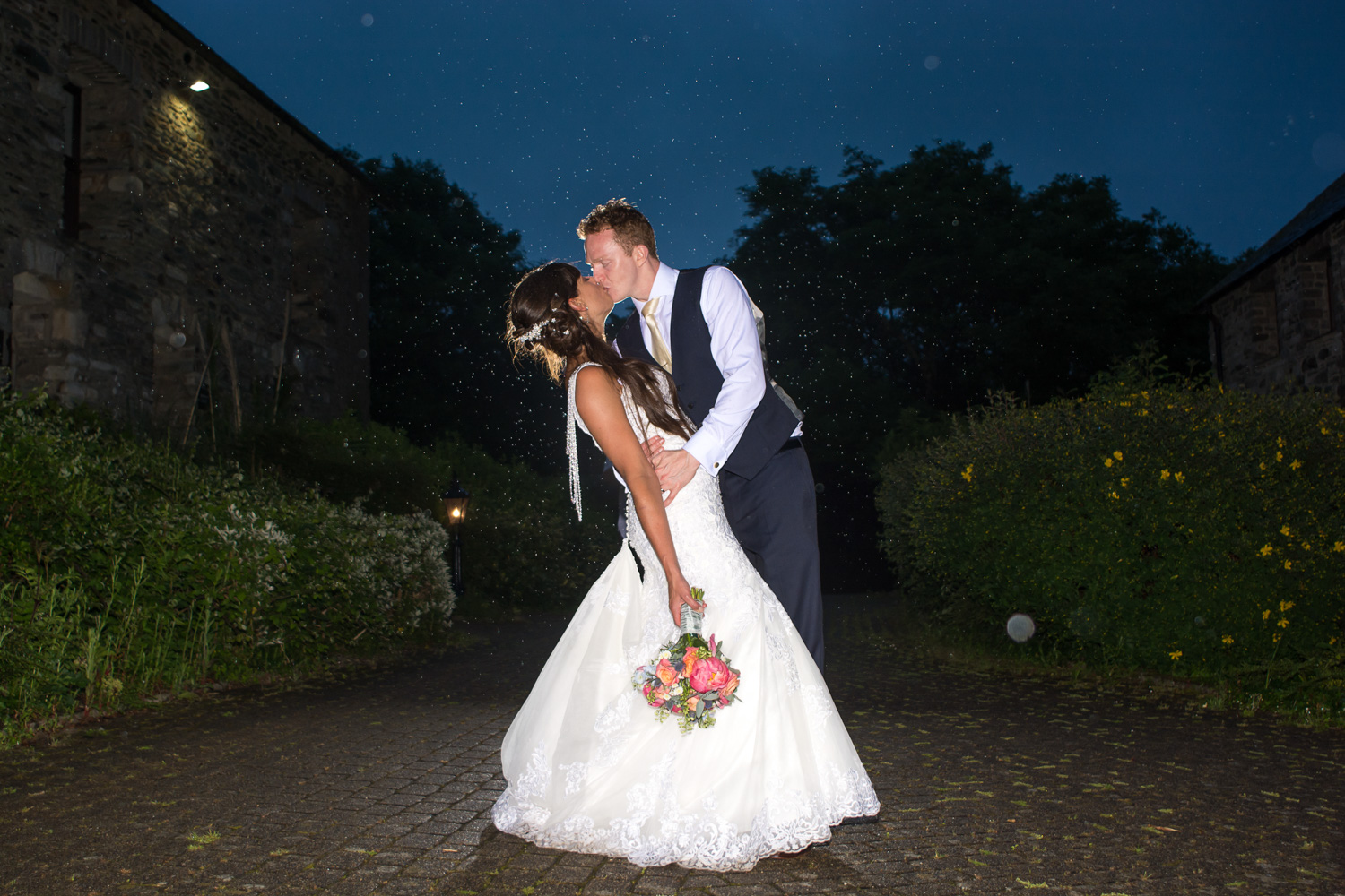 Bride and Groom kissing in the rain at their Boringdon Hall Plymouth wedding