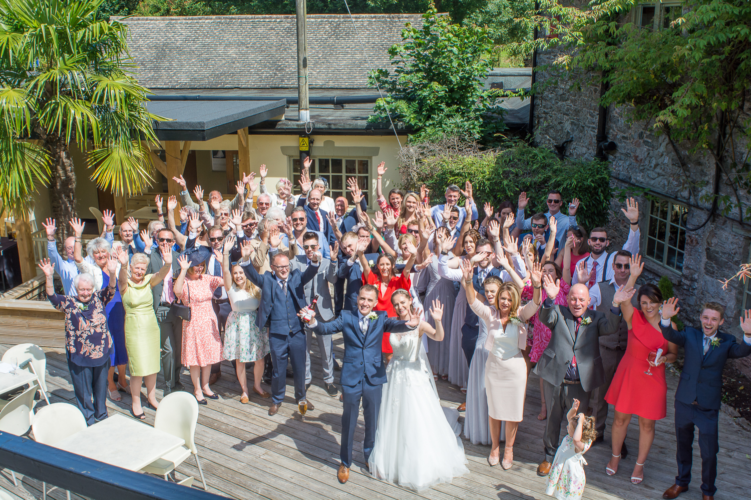 Big group photo from above on the decking at the Bickley Mill wedding venue in Devon