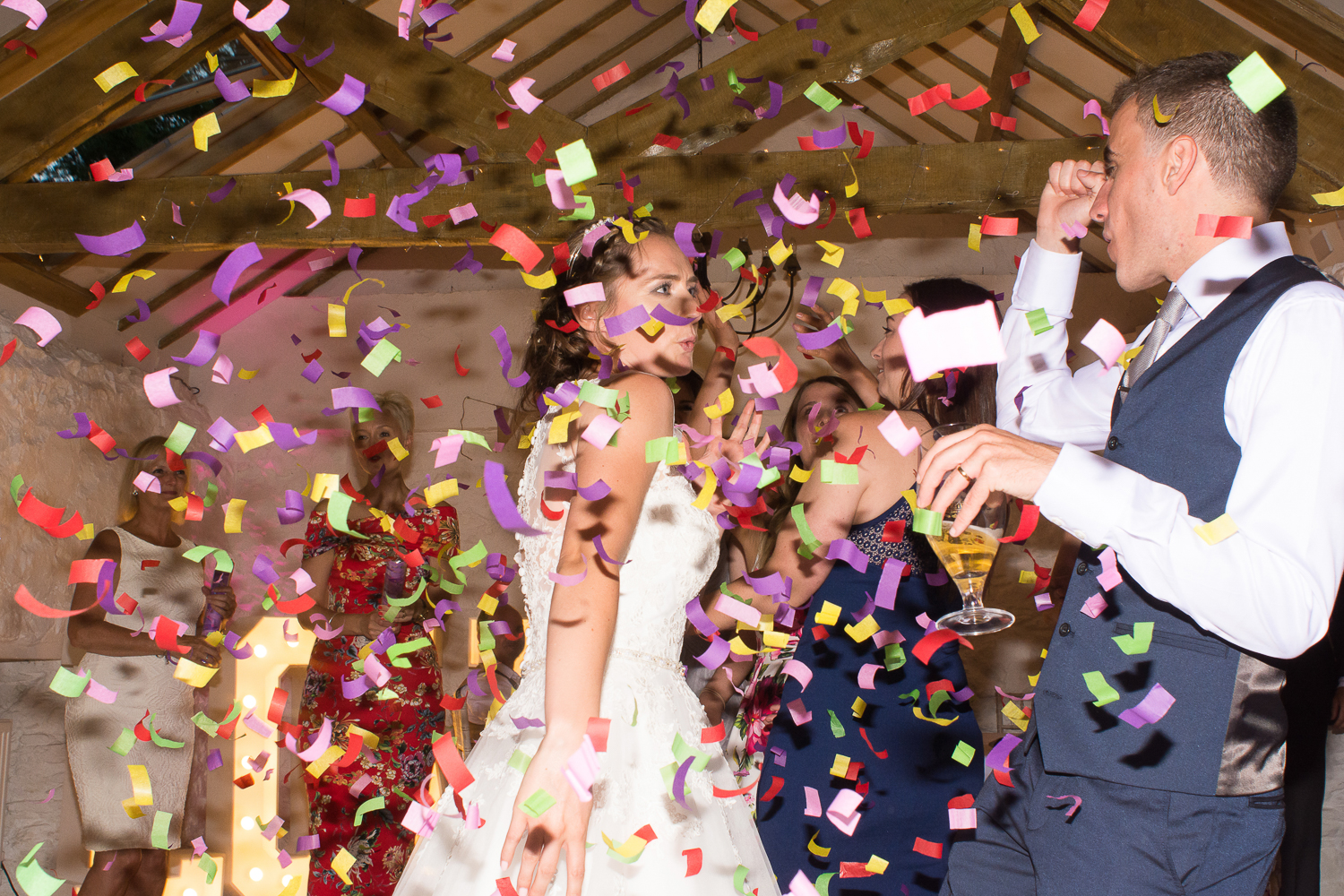 Confetti covers the bride and groom on the dance floor at the Bickley Mill wedding venue in Devon