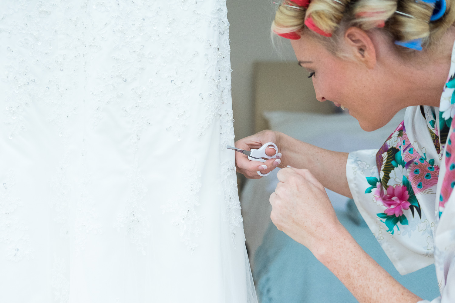 Bride cutting loose threads off her dress in woolacombe devon