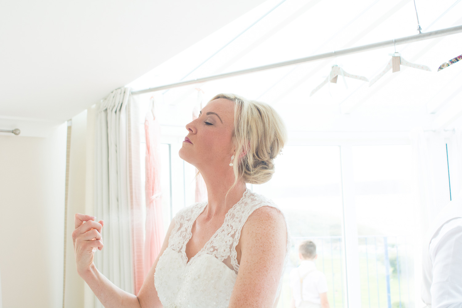 bride putting perfume on in beautiful light in woolacombe