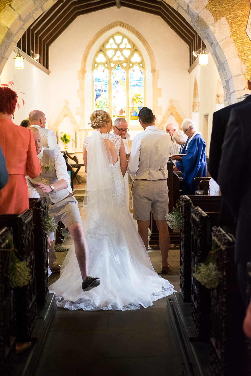 big step over the brides dress during the ceremony at st mary's church in woolacombe