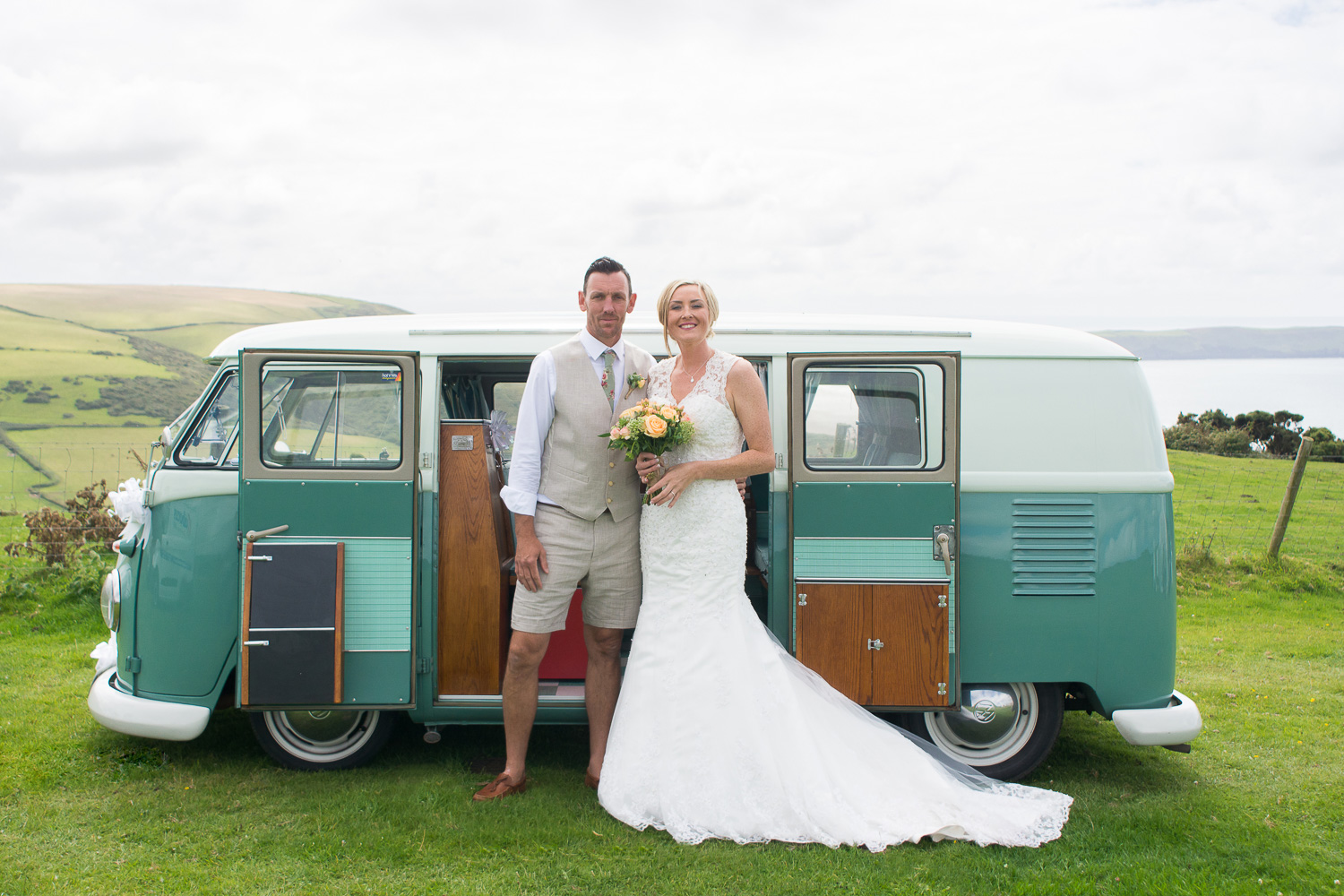 bride and groom with their vw camper on a woolacombe cliff top