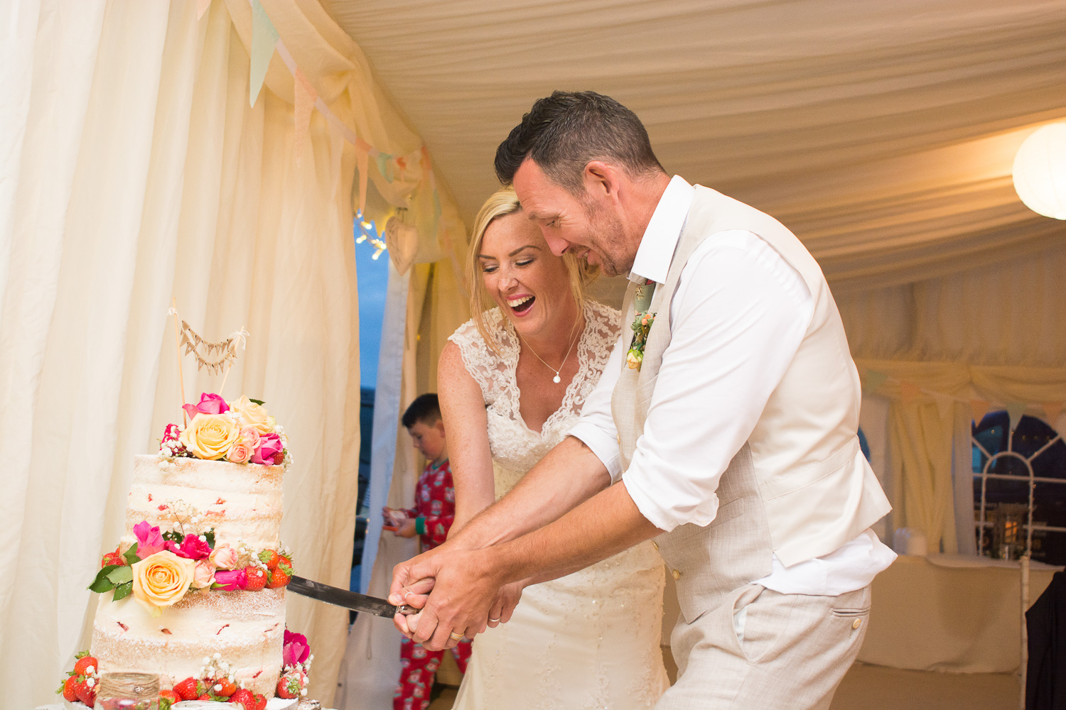 cutting the cake at their woolacombe wedding